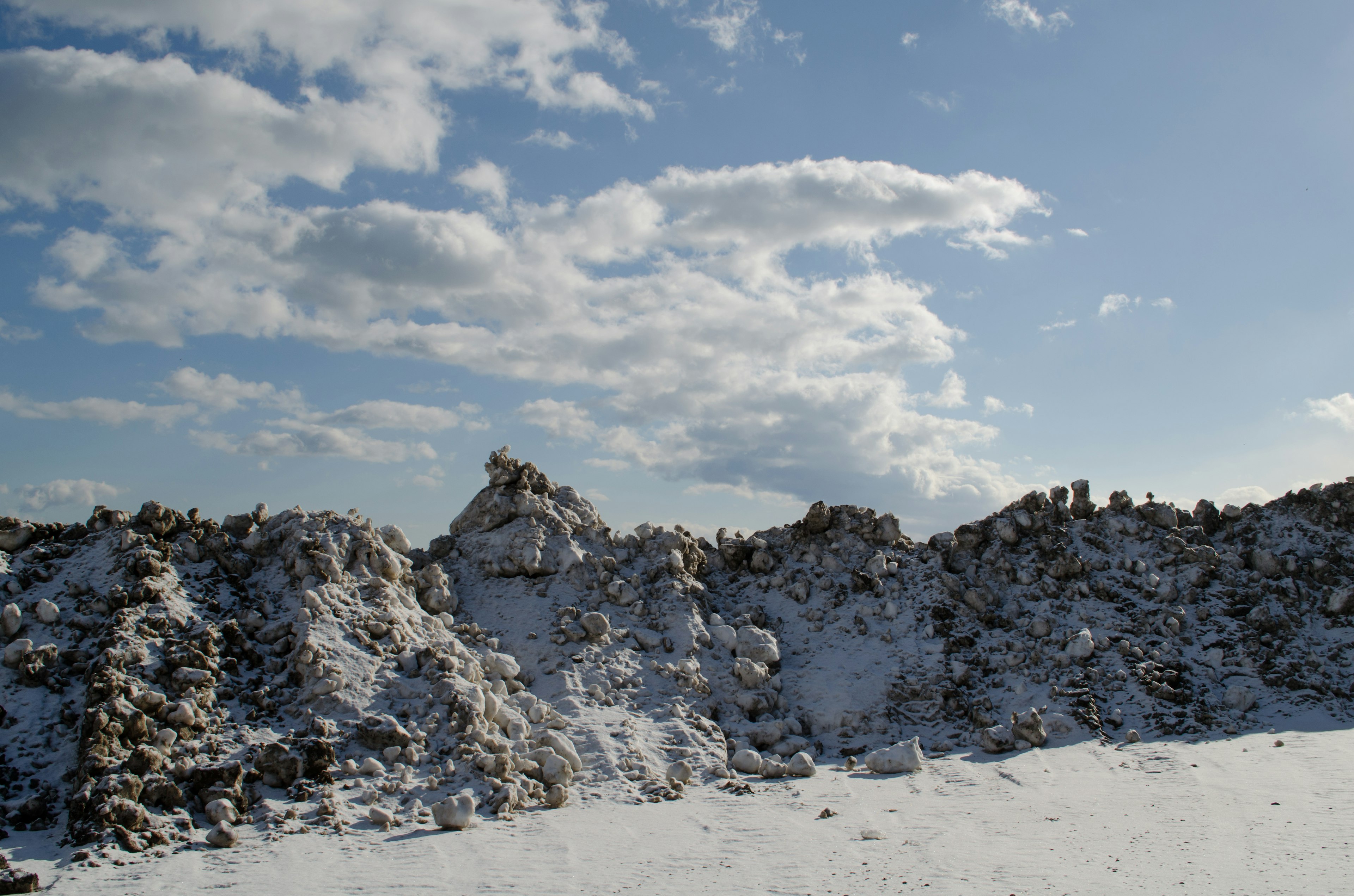 Piles of snow-covered stones against a clear blue sky