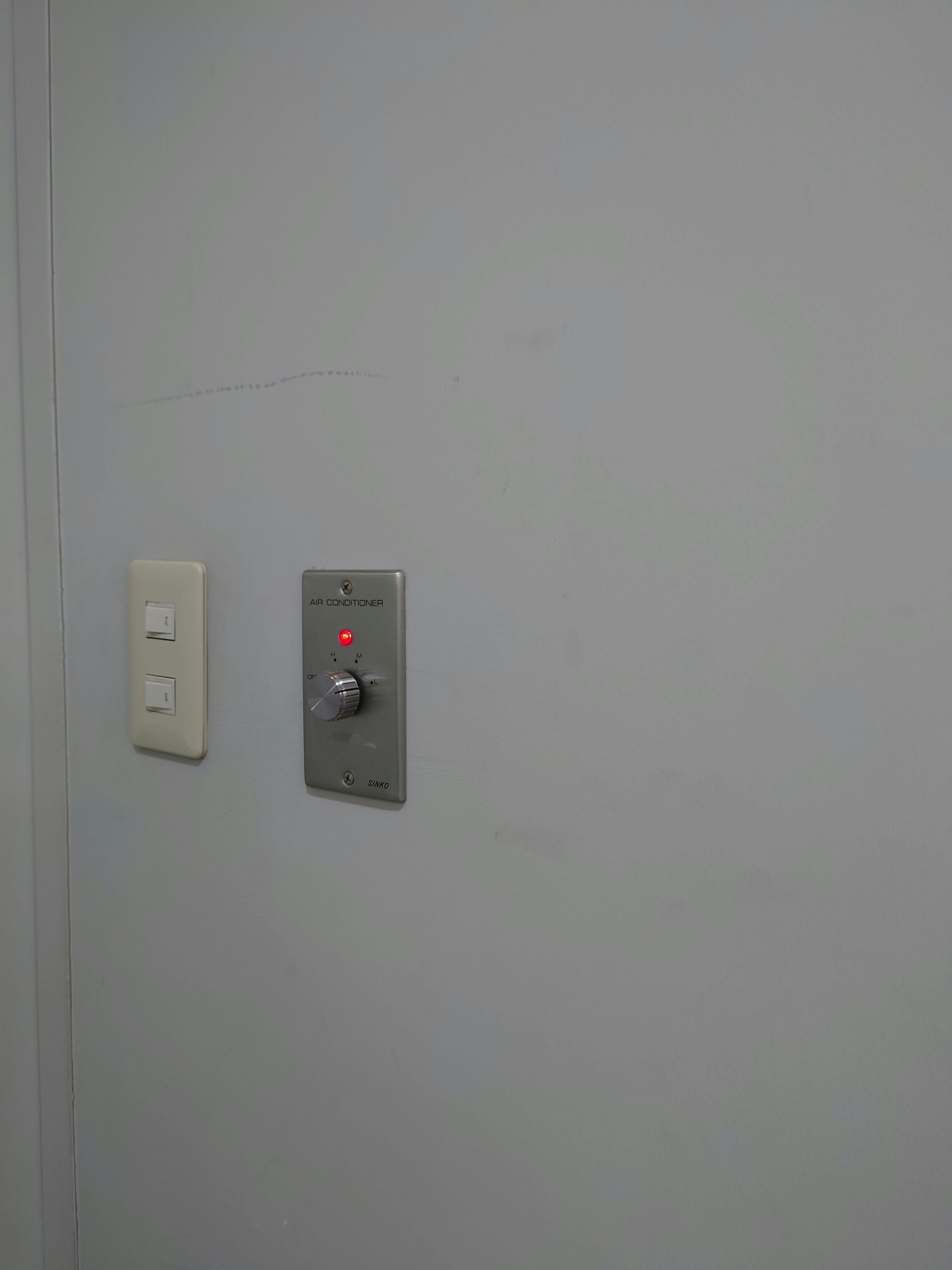 Panel de interruptor y botón montado en una pared blanca