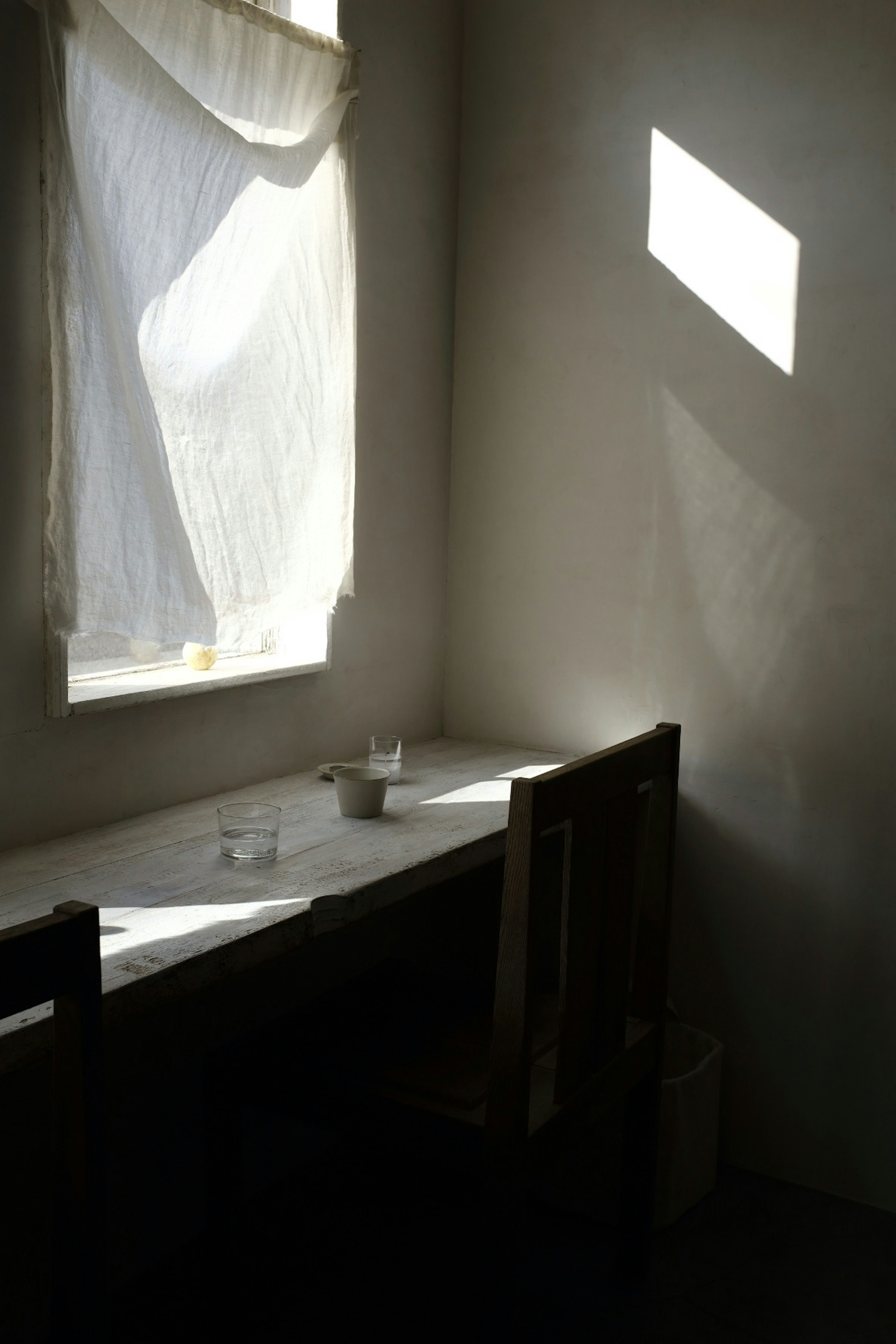 Une pièce calme avec une fenêtre lumineuse et une table simple