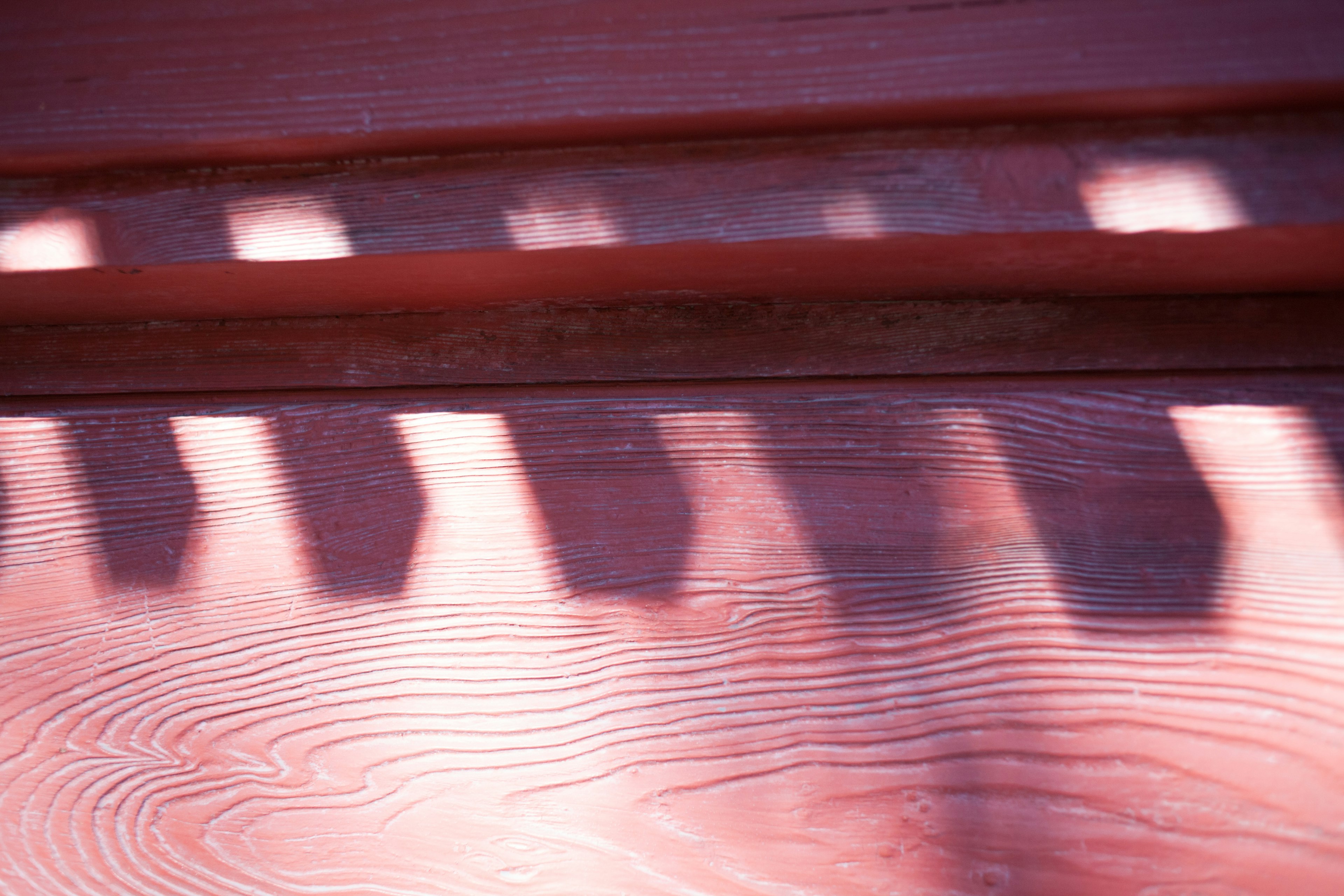 Contraste de luz y sombras sobre una superficie de madera roja