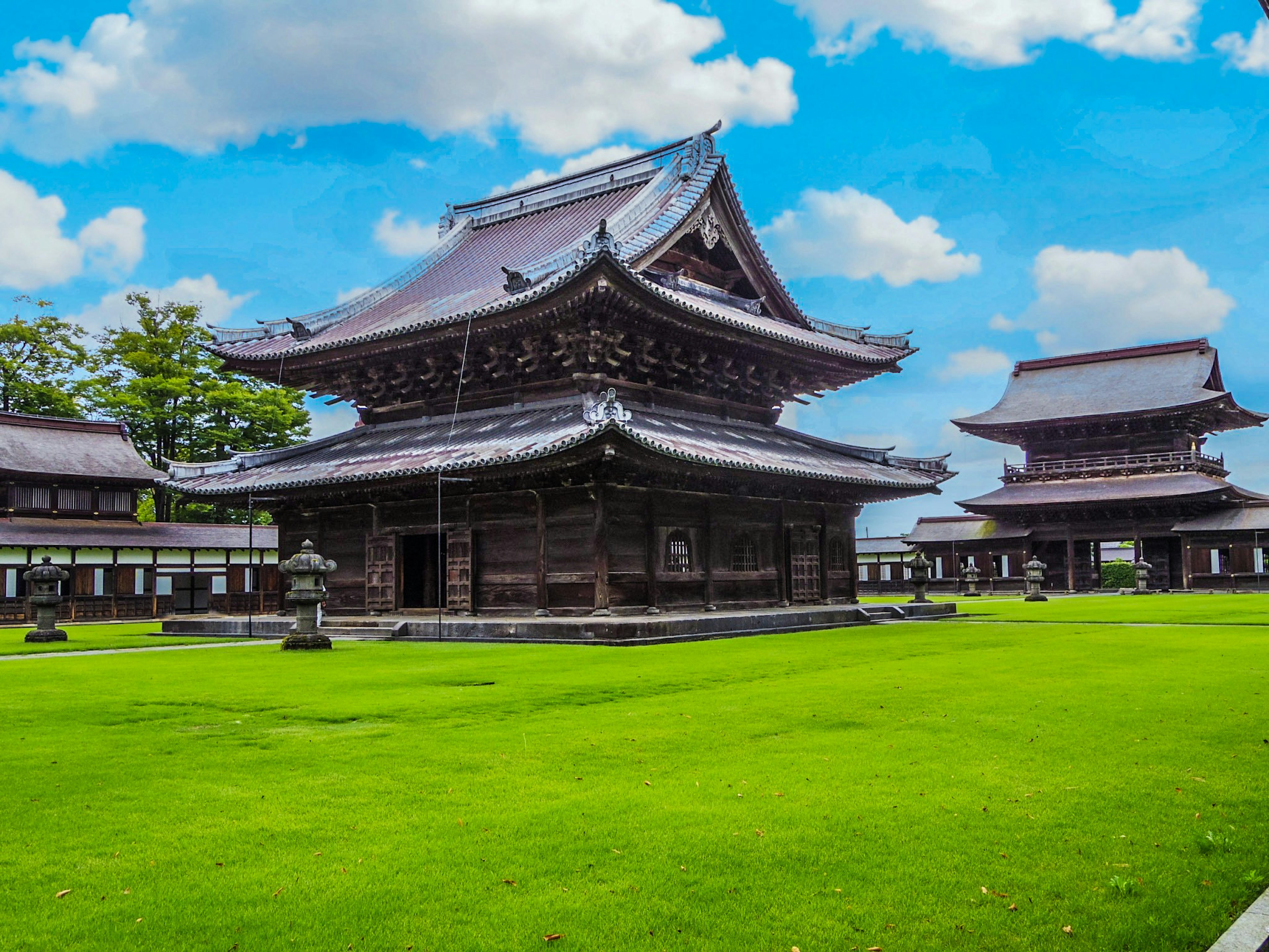 Temple japonais traditionnel avec une vaste pelouse verte sous un beau ciel bleu