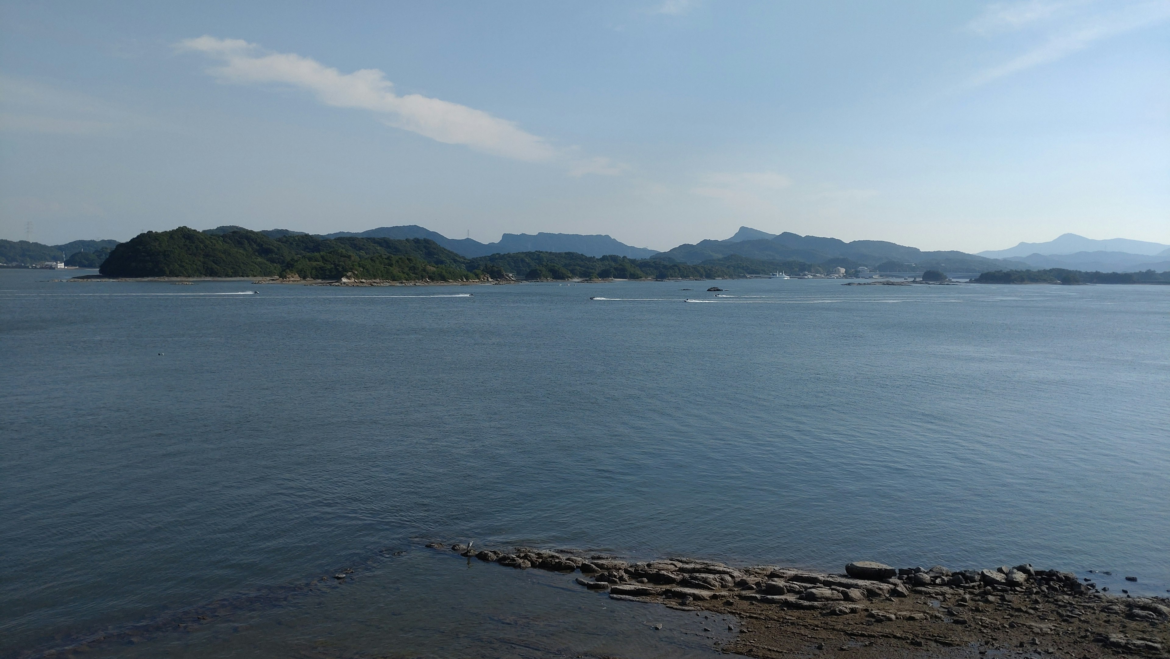 穏やかな海の景色と遠くの山々が見える風景