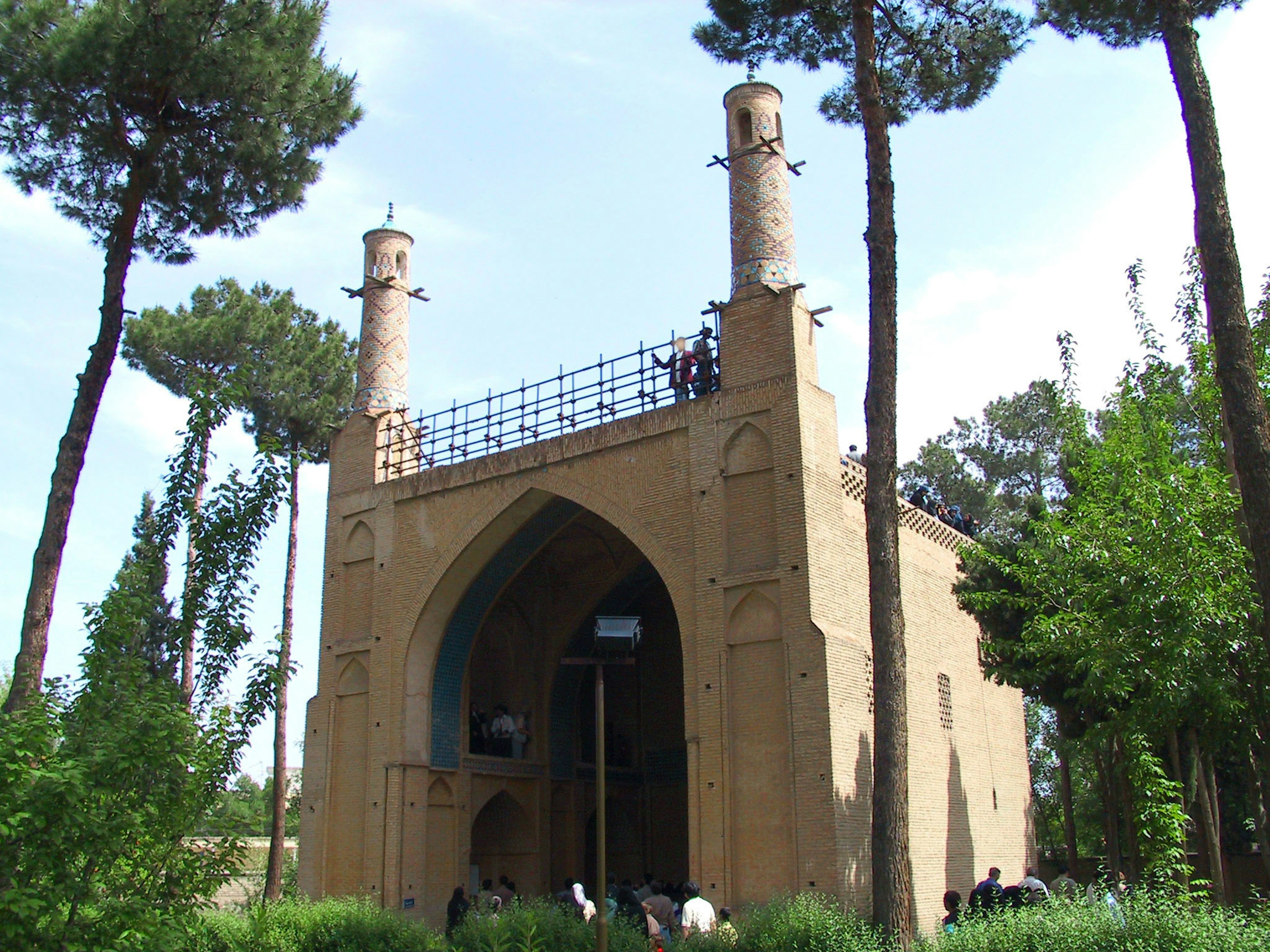 Ancient building with tall towers surrounded by green trees