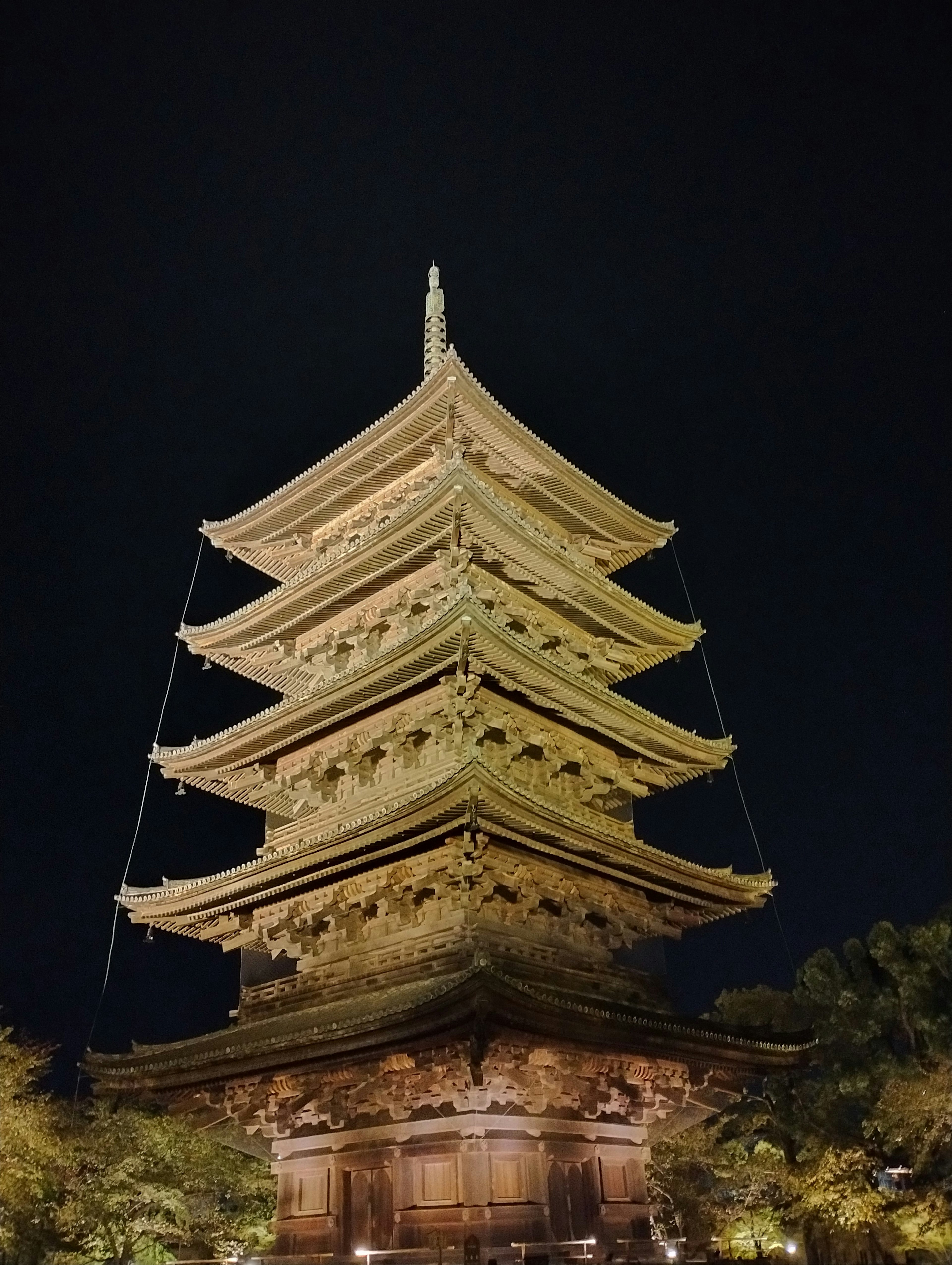 Pagode illuminée la nuit montrant des détails complexes