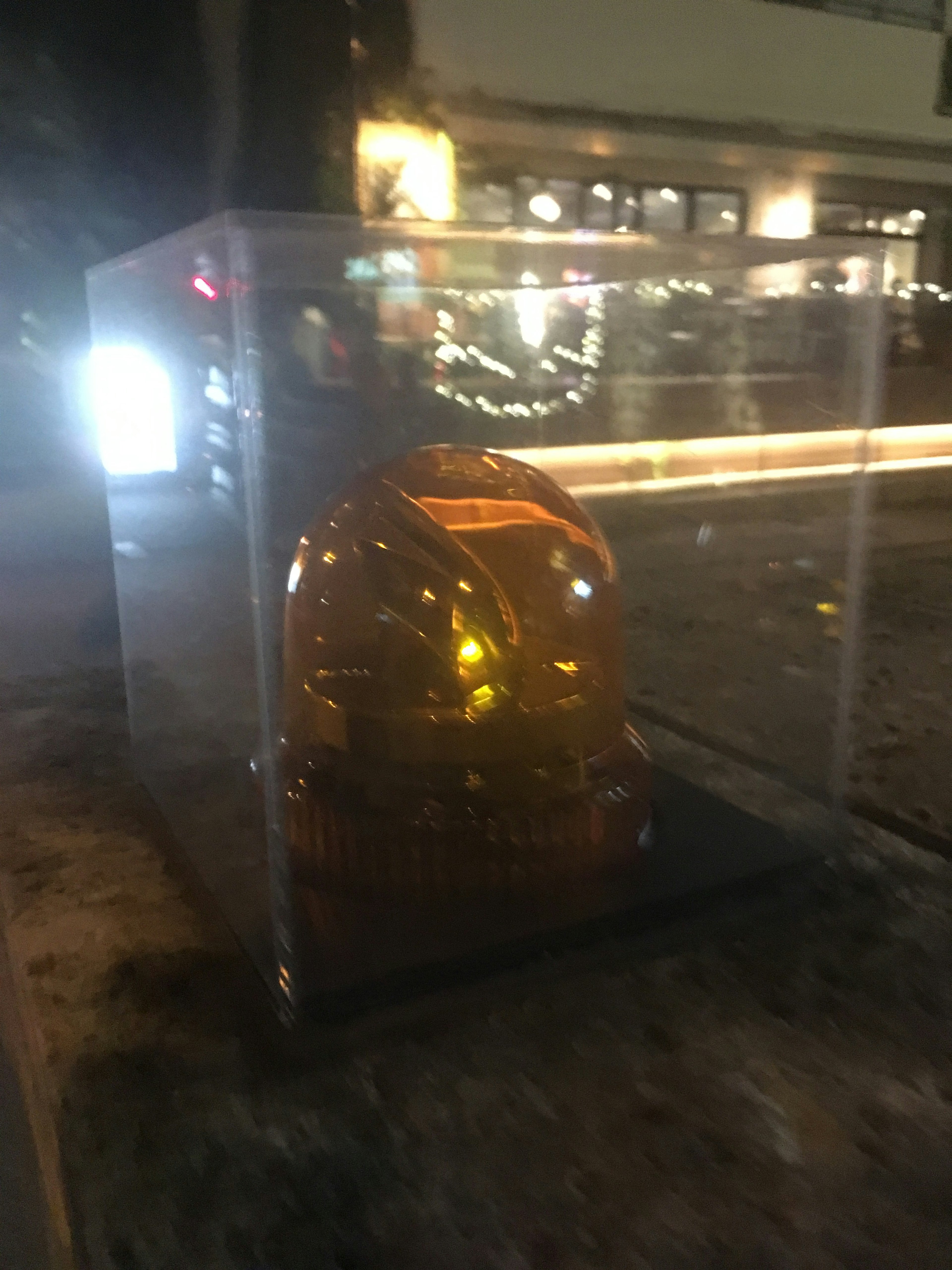 Objet orange enfermé dans une boîte transparente sur une rue de la ville la nuit