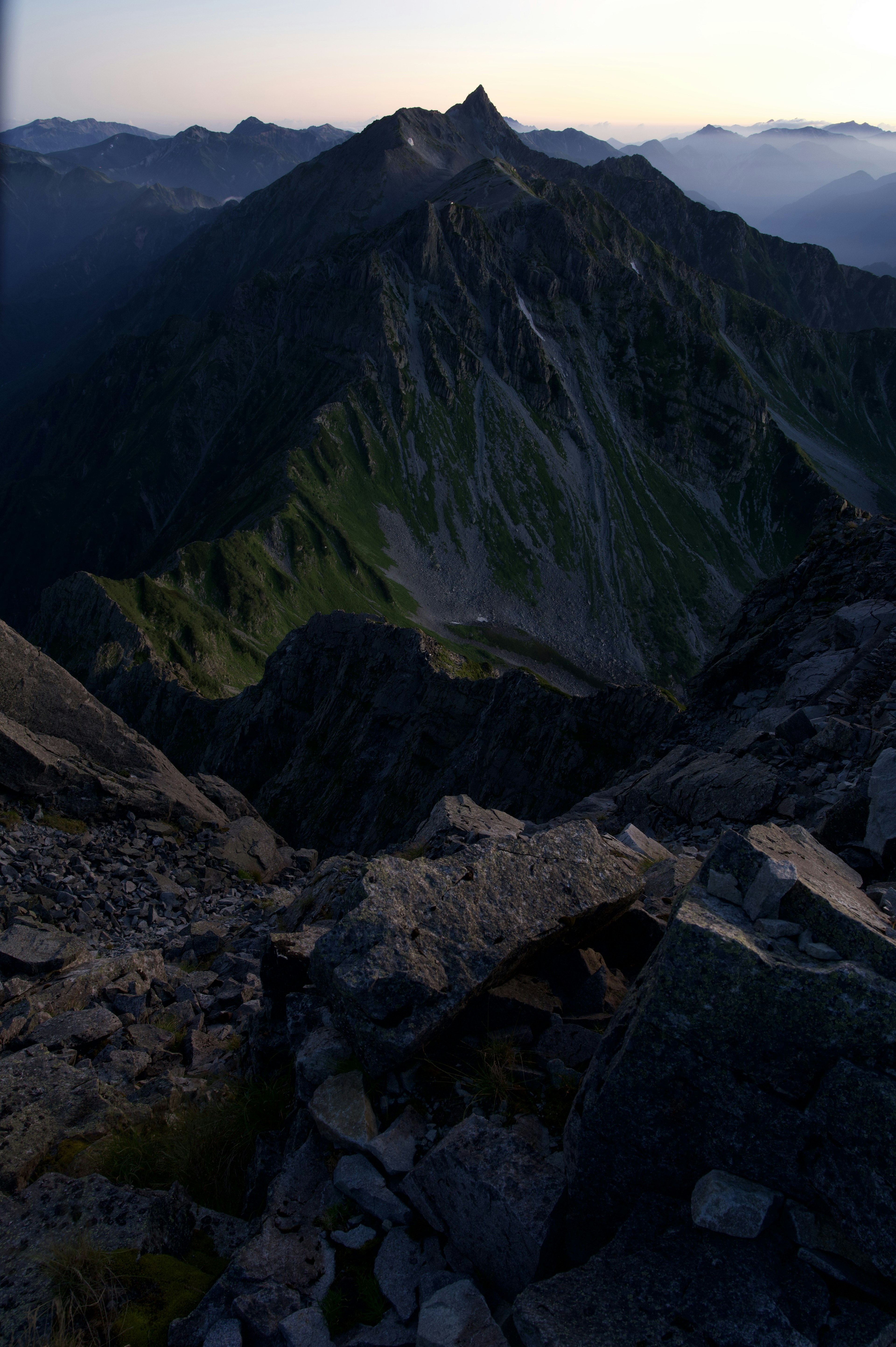 Paysage de sommet de montagne avec des pentes vertes et des formations rocheuses