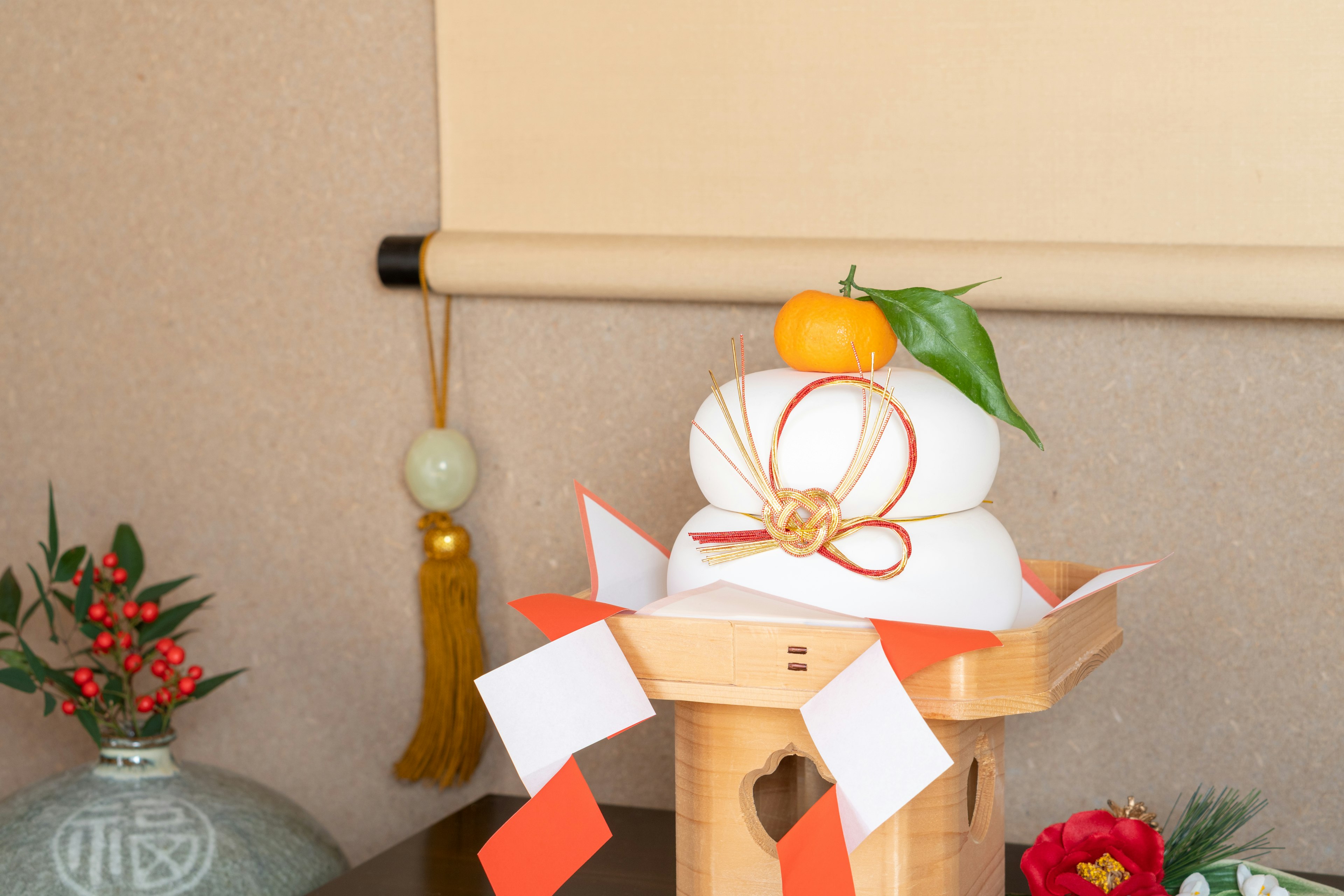 Traditional Japanese New Year decoration featuring kagami mochi and a mandarin orange