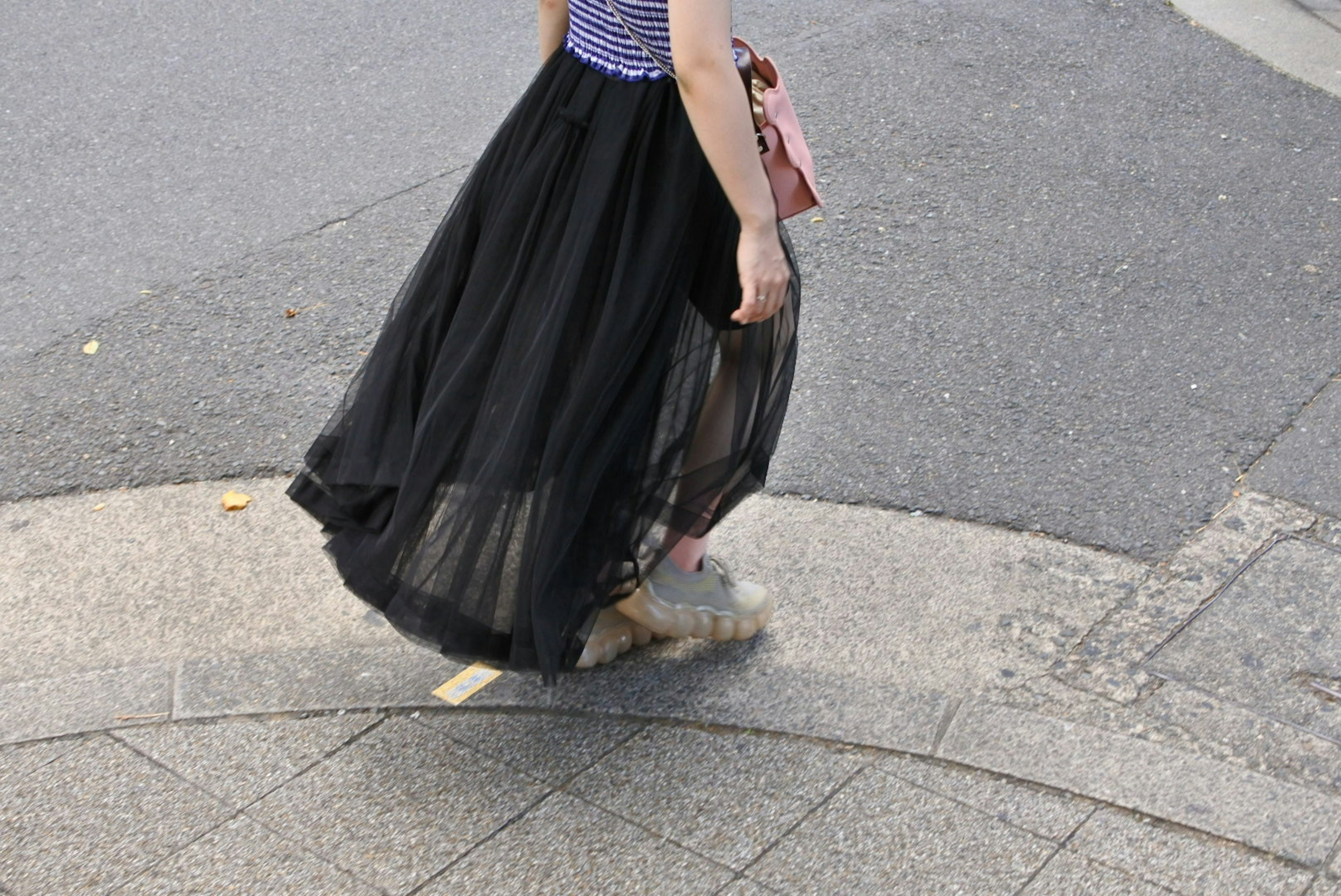 Une femme marchant au coin de la rue avec une jupe en tulle noire