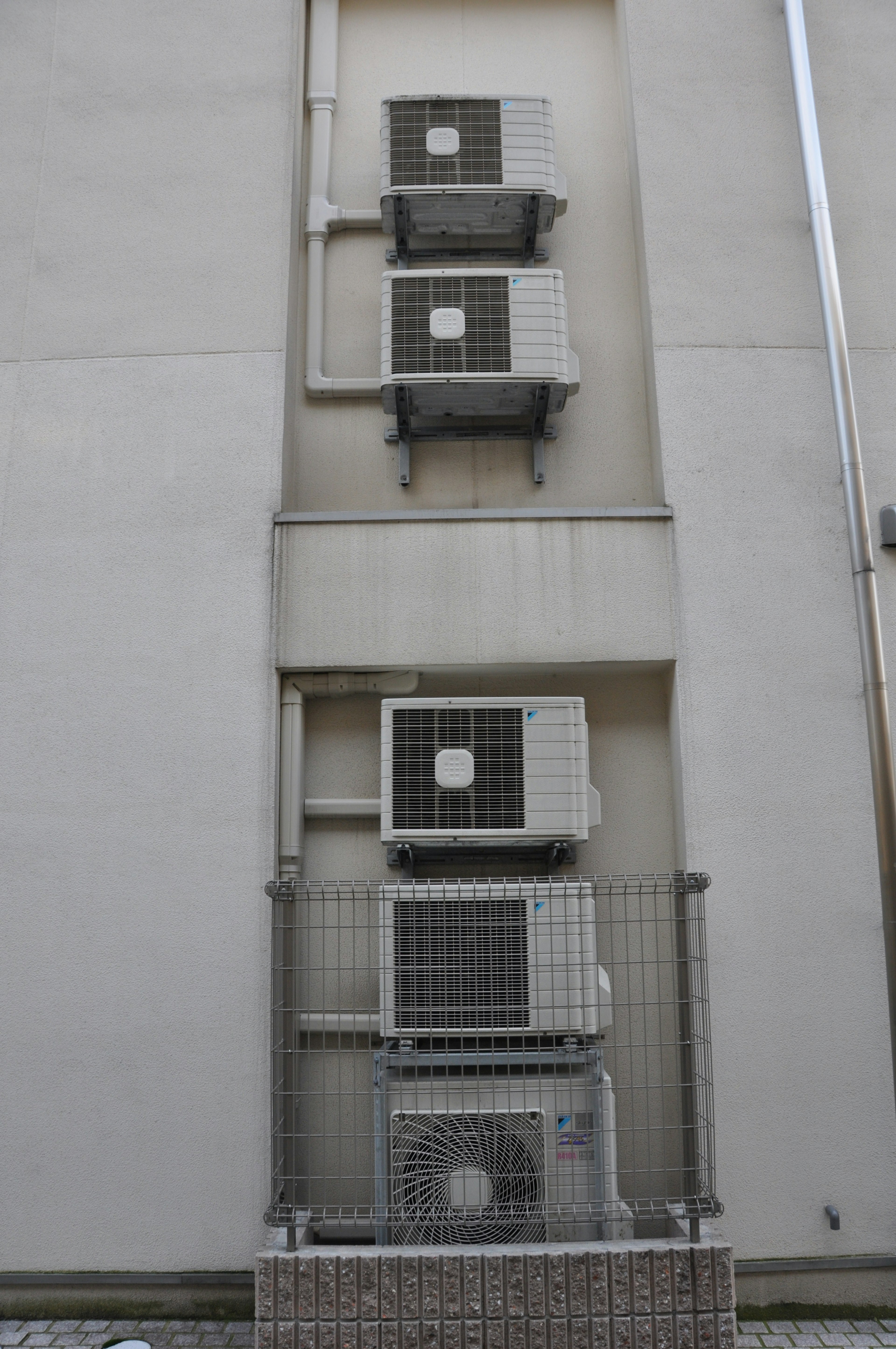 Four air conditioning units mounted on a building wall