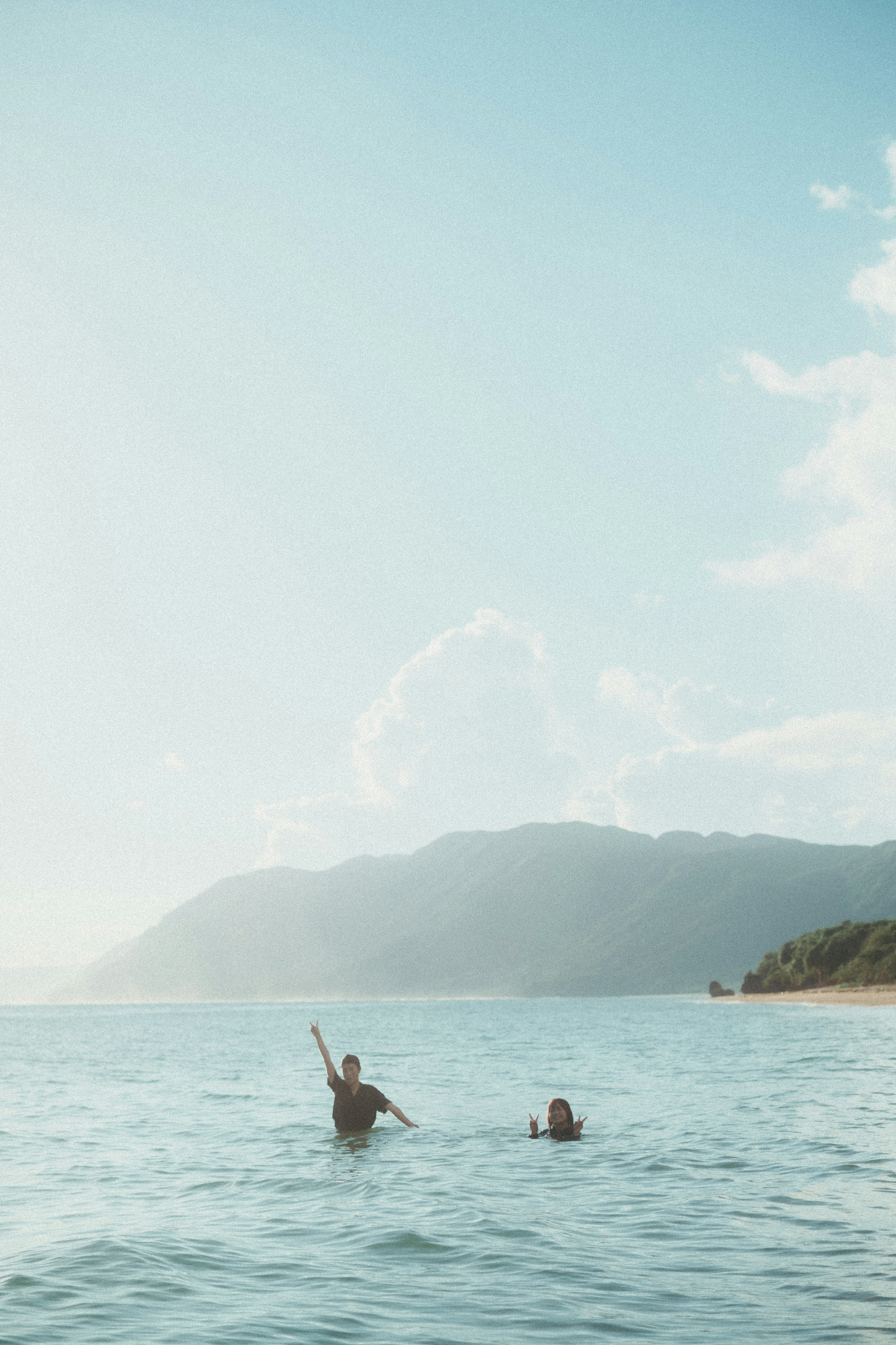 Two people enjoying the water with a blue sky