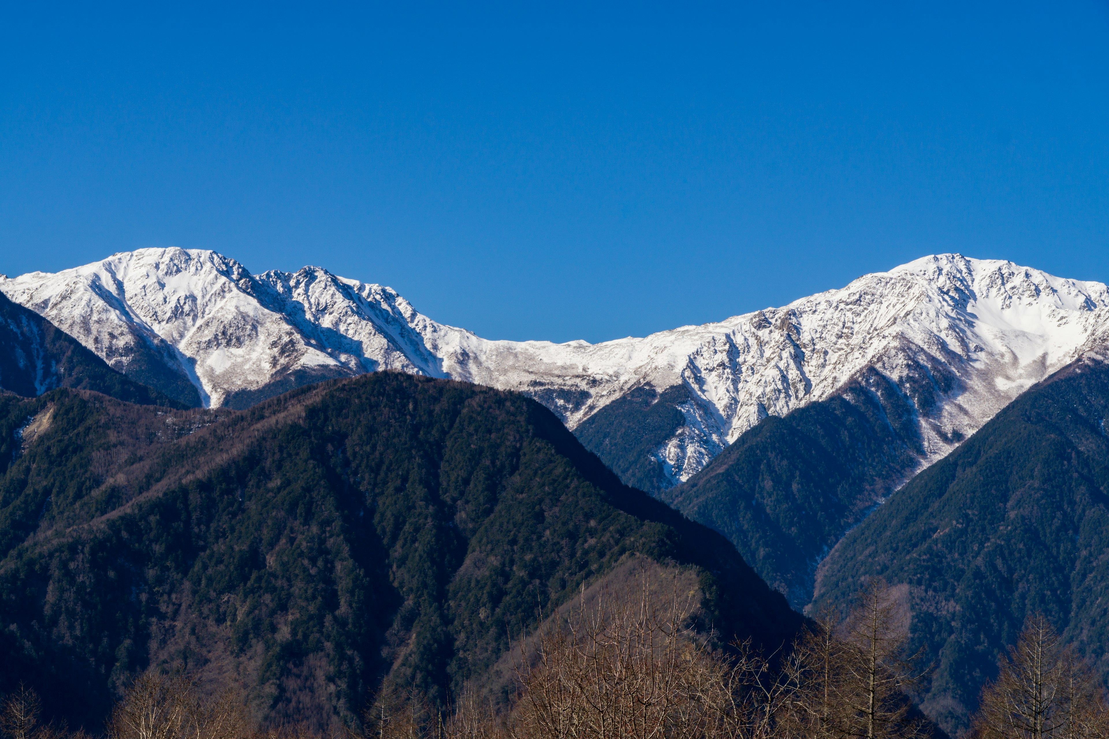 Montagne innevate sotto un cielo blu chiaro