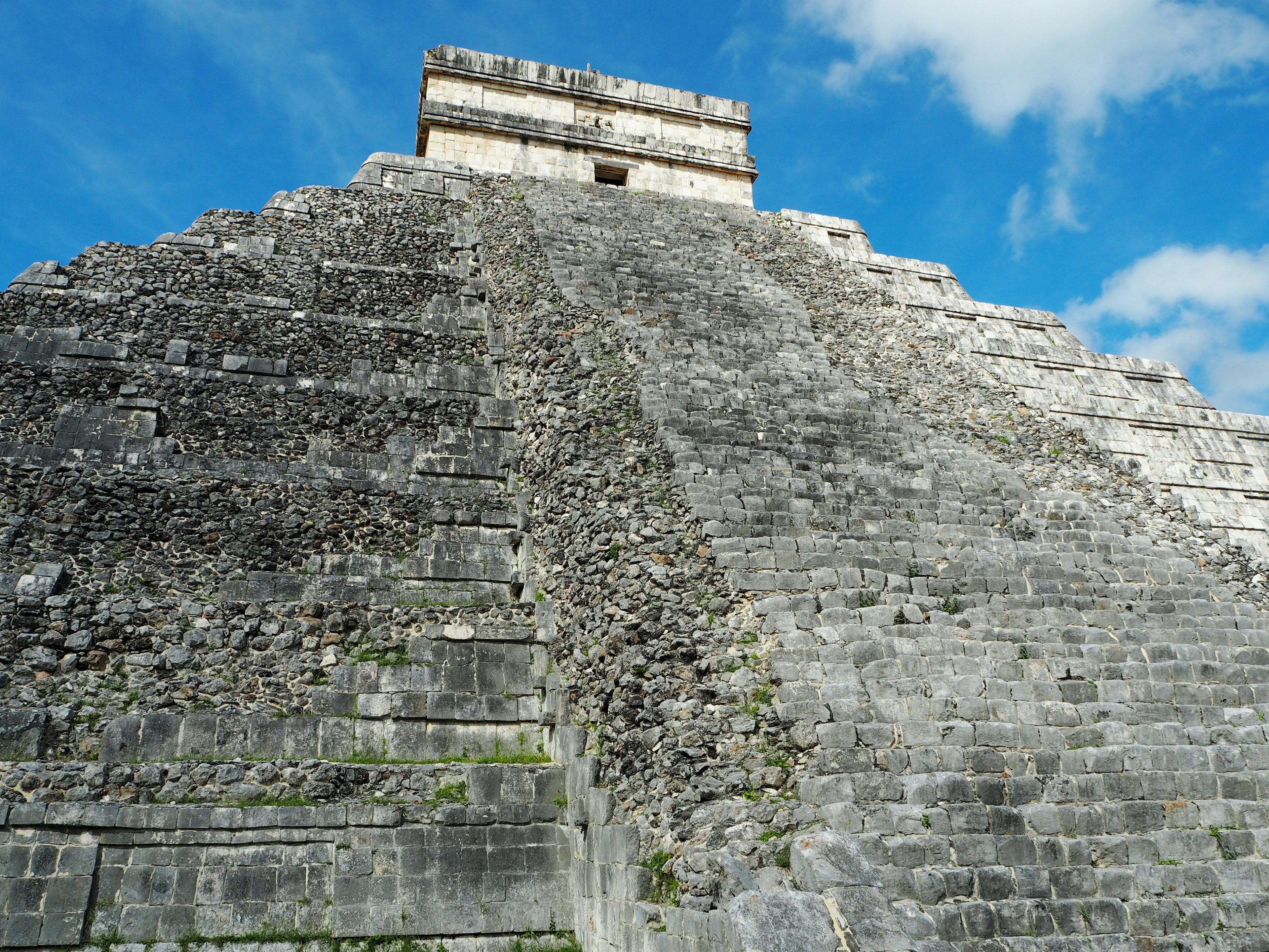 Vista laterale della piramide di Chichen Itza con dettagli delle scale di pietra e cielo blu