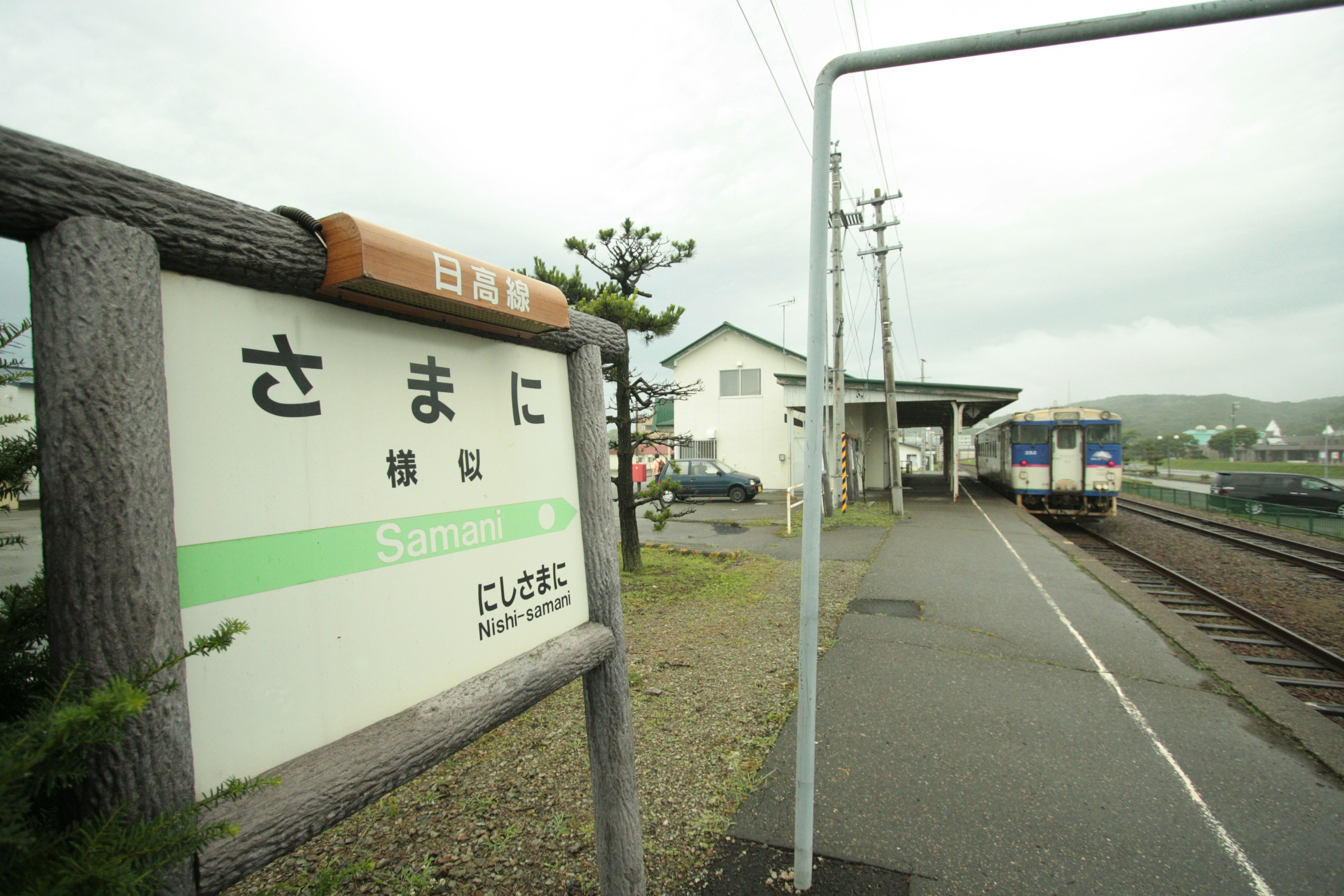 さまに駅の看板と列車の停車場の風景