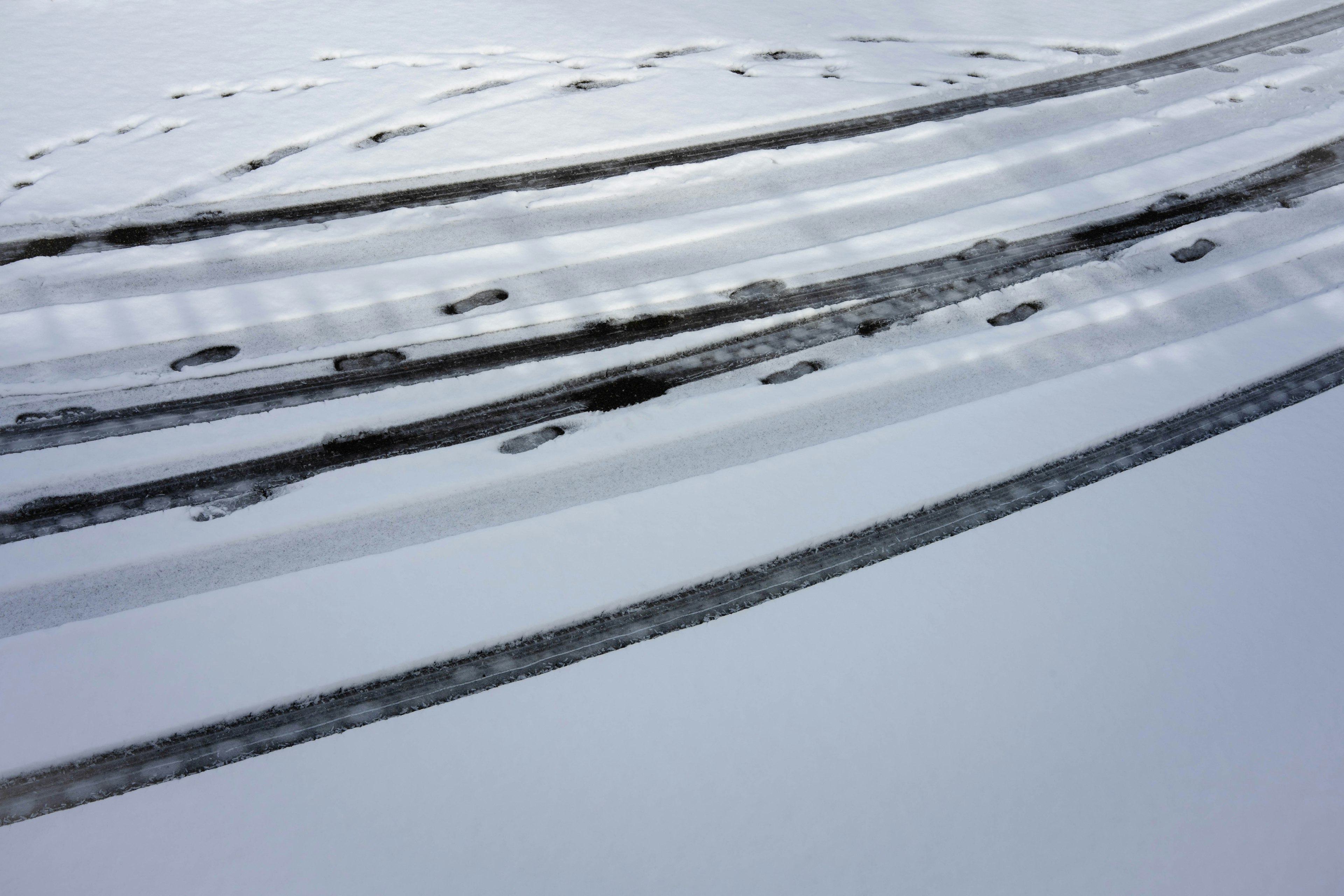 雪の上に残る滑らかなタイヤ跡と滑走跡