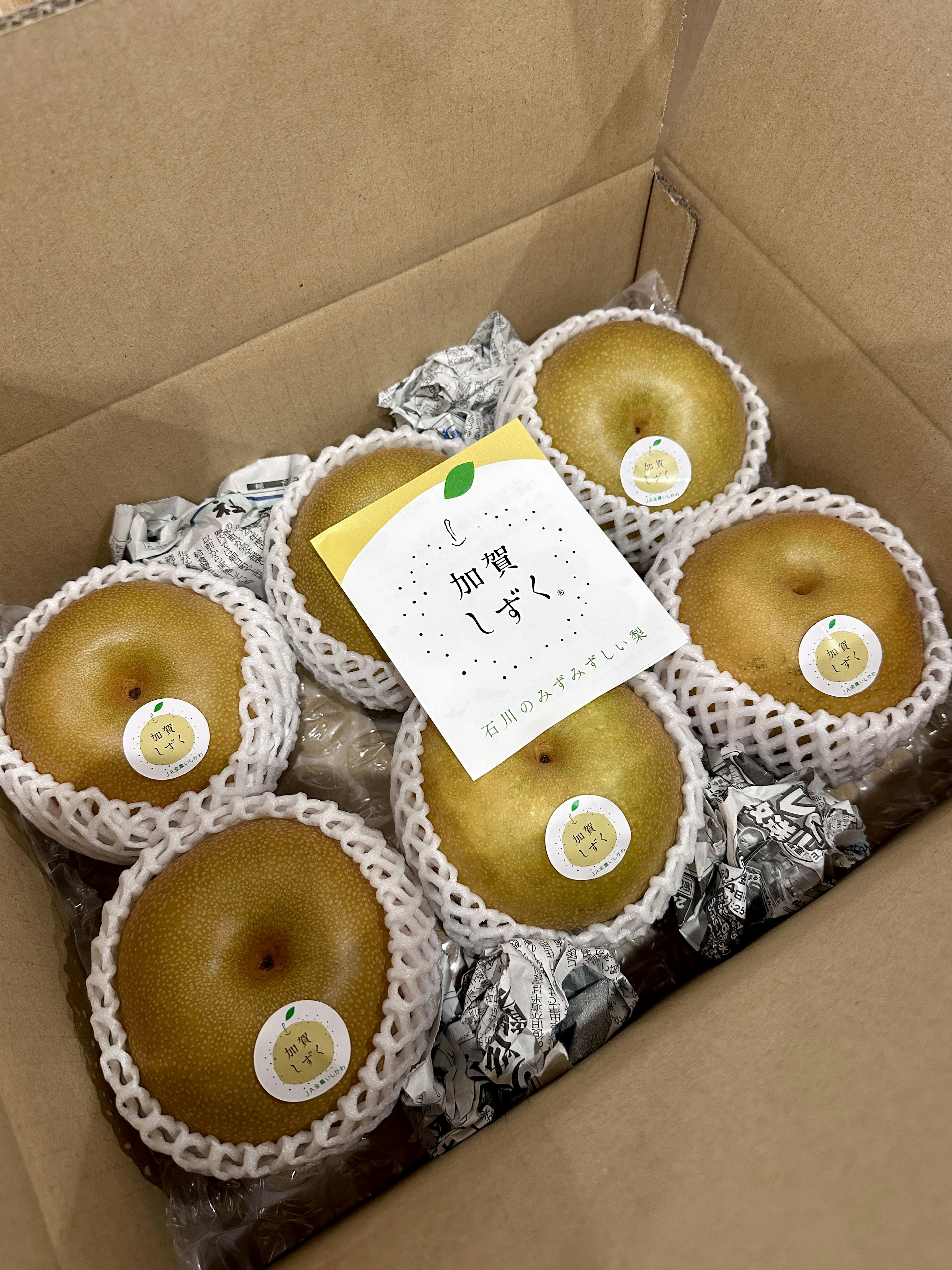 A box containing fresh pears arranged neatly