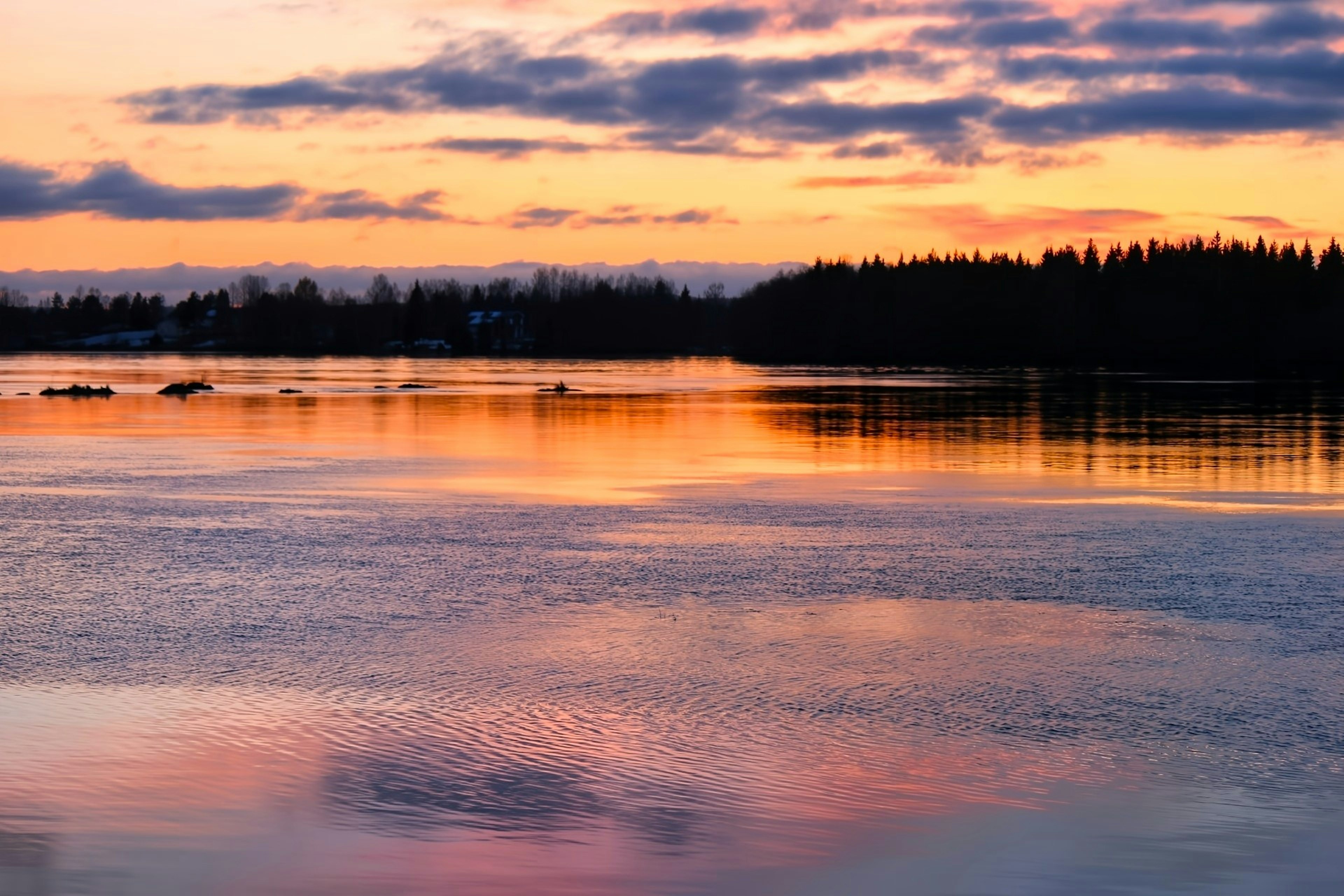 Sonnenuntergangsreflexion auf dem See mit Wolkensilhouetten