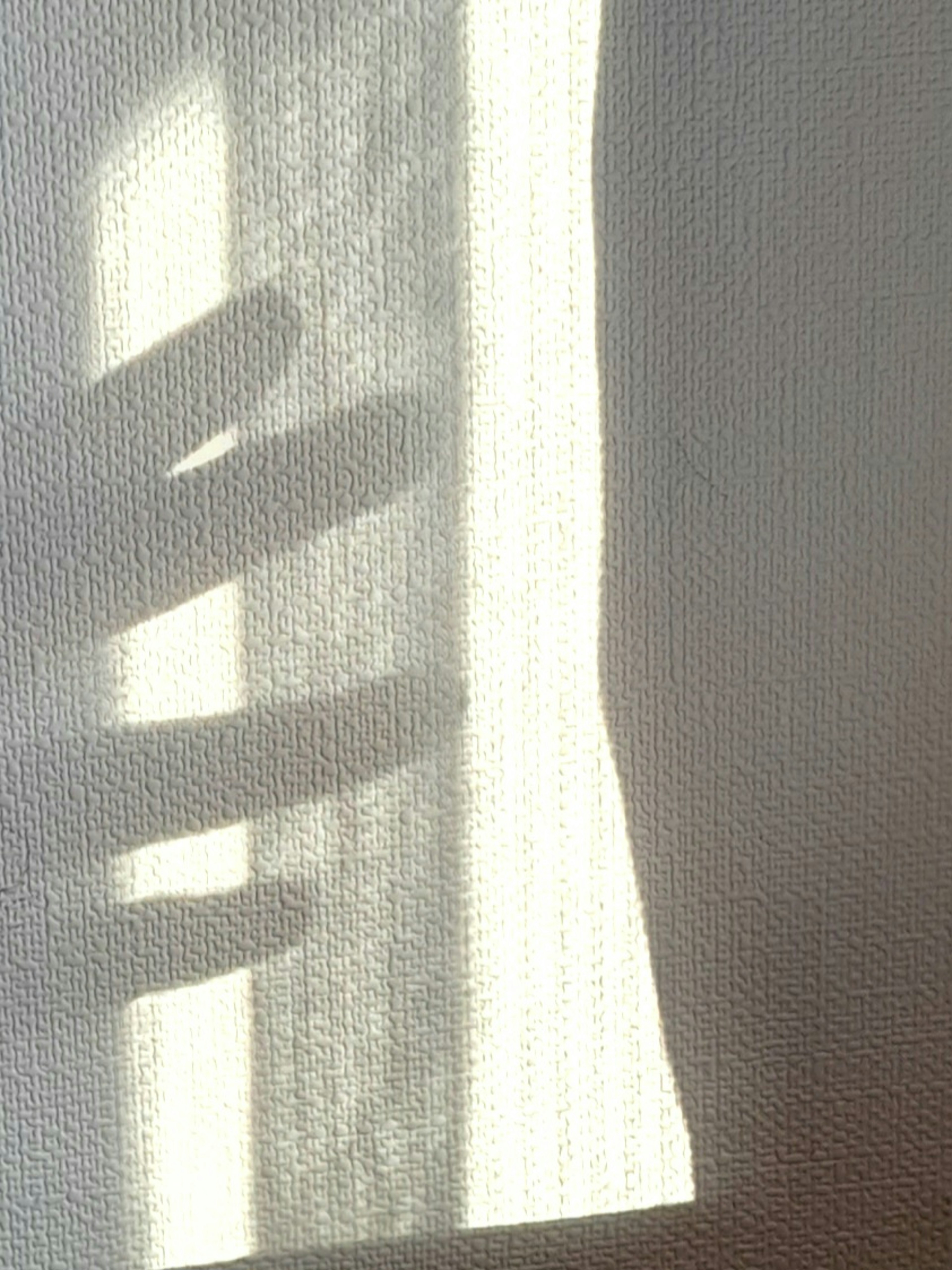 Ombre de main projetée sur un mur blanc avec de la lumière