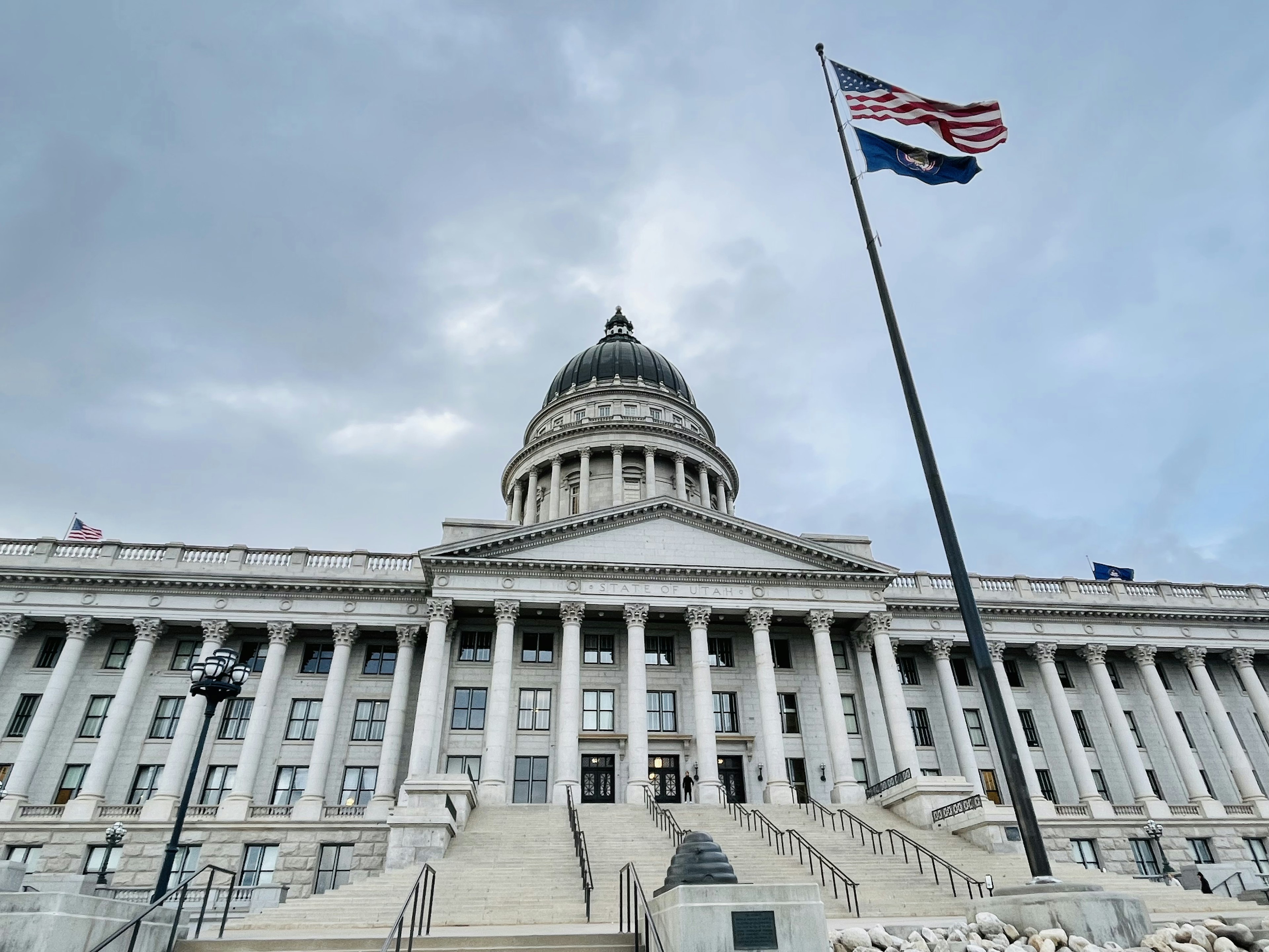 Außenansicht des Kapitols des Bundesstaates Utah mit großen Treppen und der amerikanischen Flagge