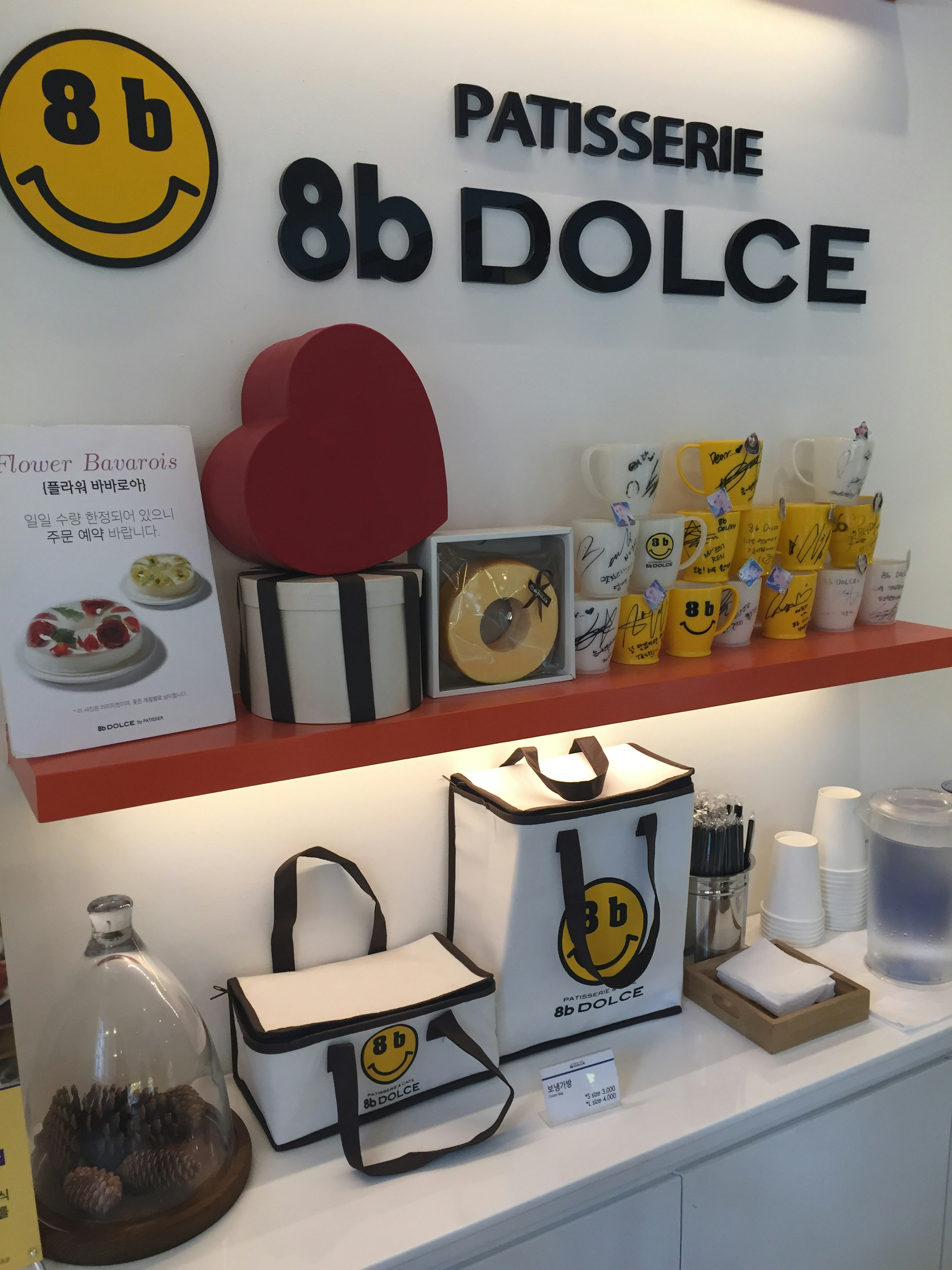 ภายในที่สว่างของ Patisserie 8b Dolce พร้อมโลโก้ยิ้มและการตกแต่งรูปหัวใจสีแดง