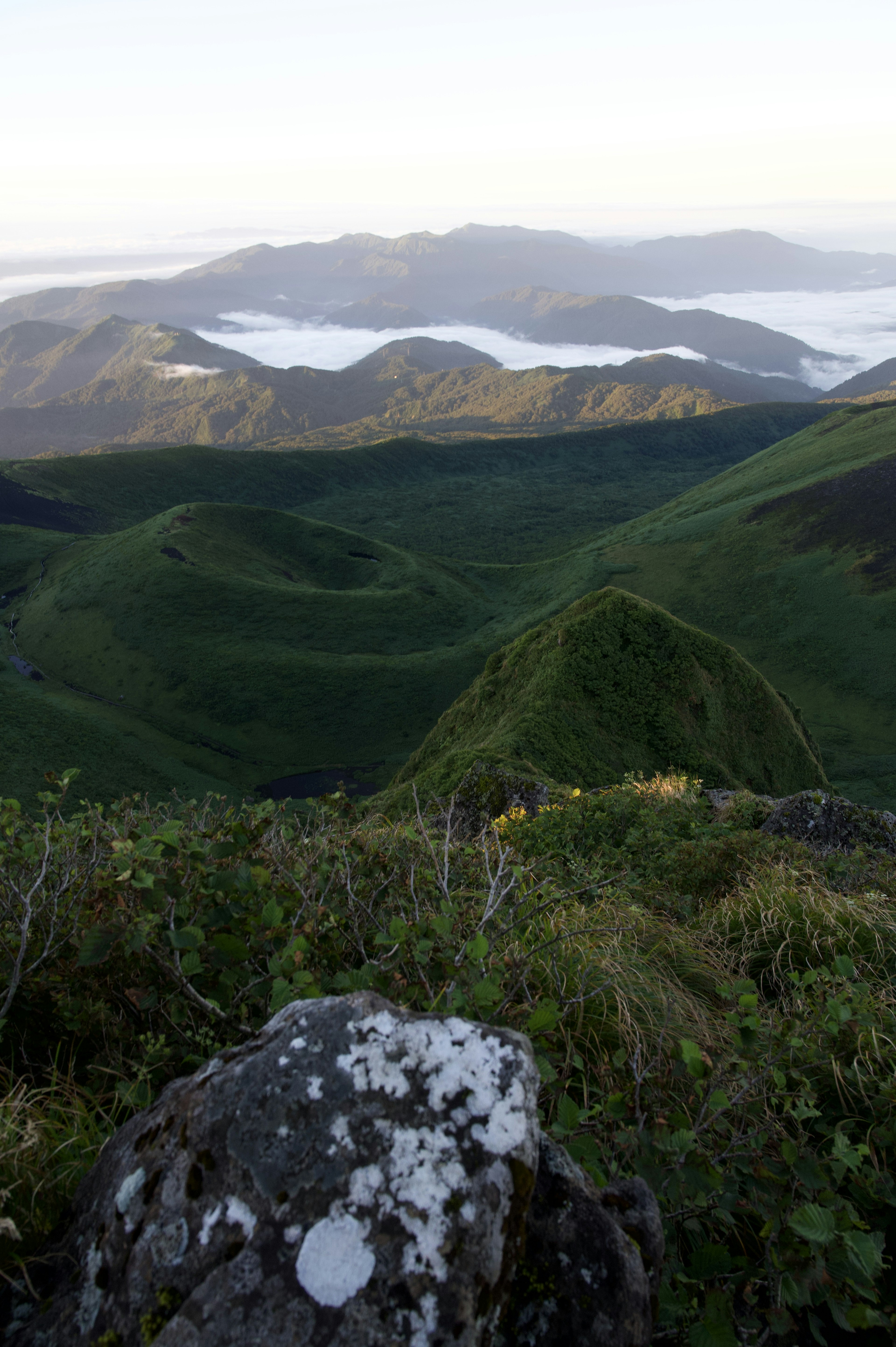 緑の丘と遠くの山が広がる風景の写真