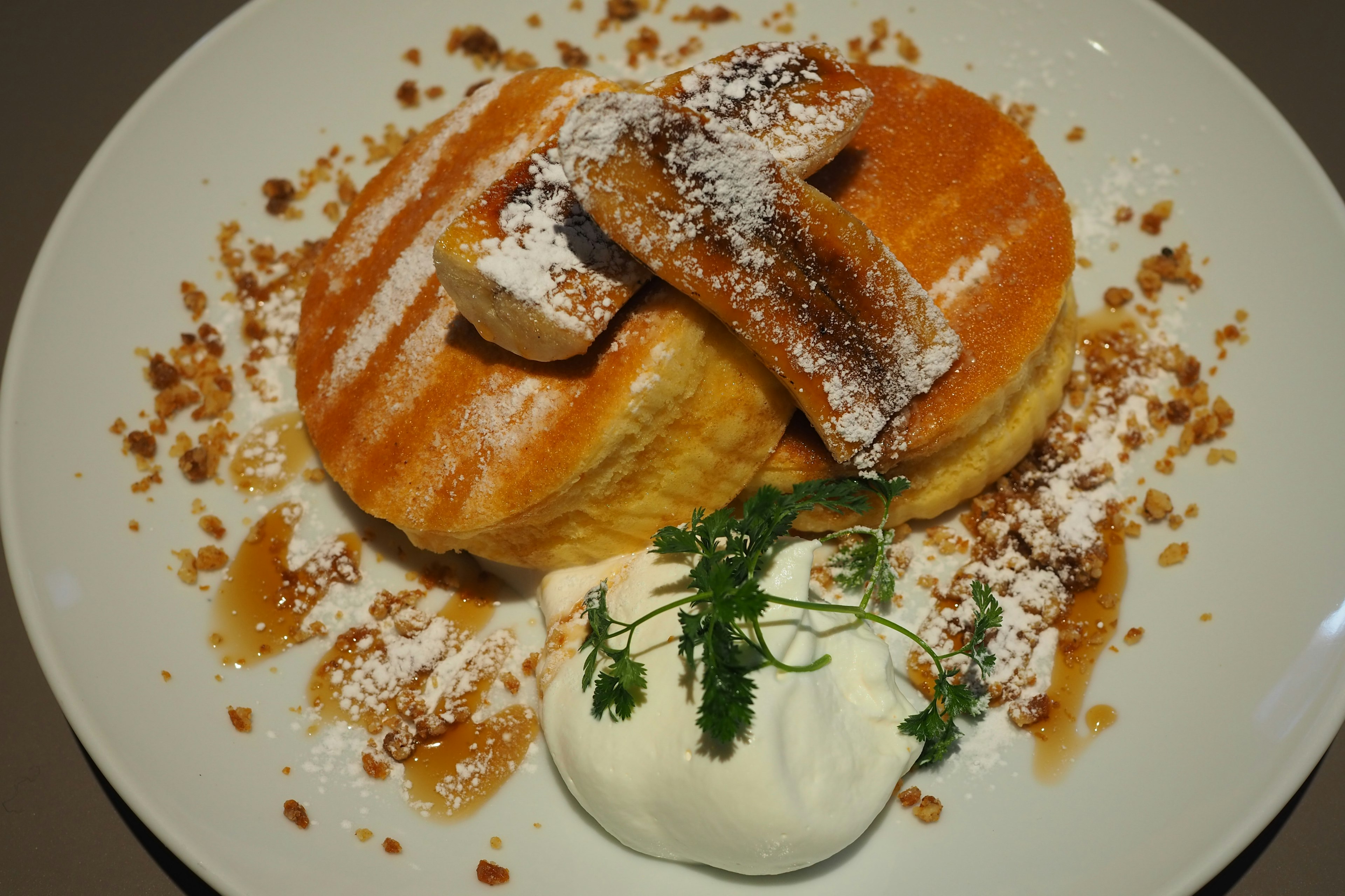 Panqueques esponjosos cubiertos con crema y azúcar en polvo