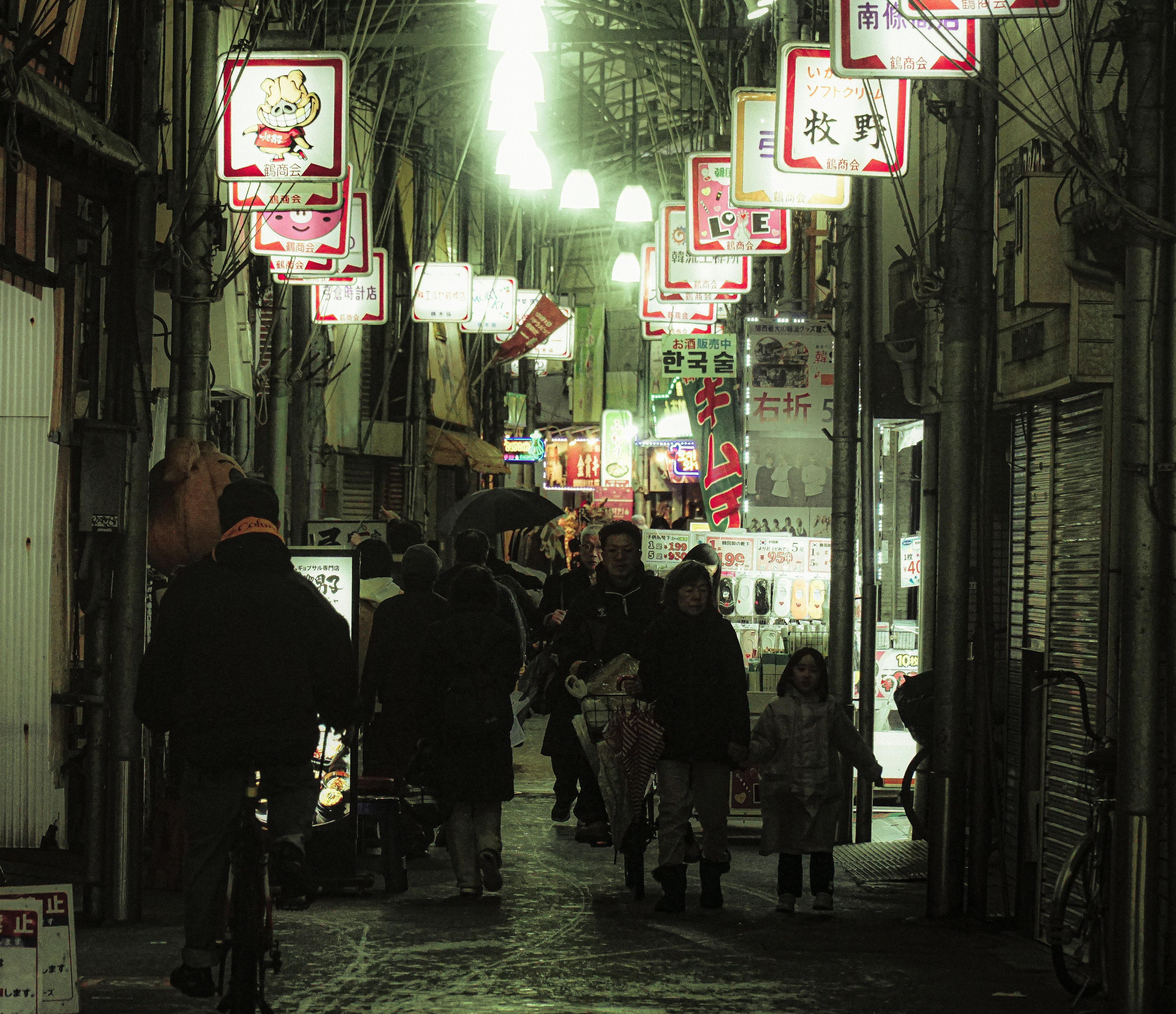 夜の商店街に並ぶ提灯と人々の光景