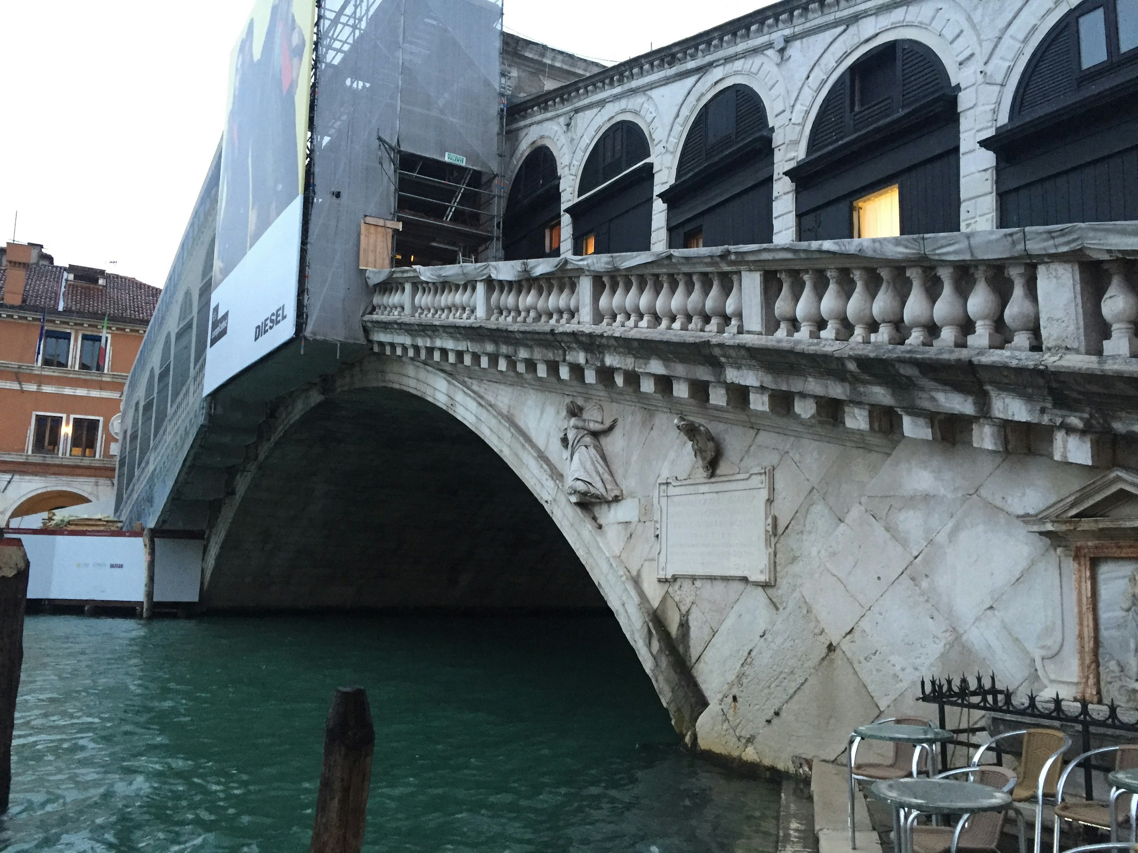 Tampilan samping Jembatan Rialto di Venesia dengan refleksi di air