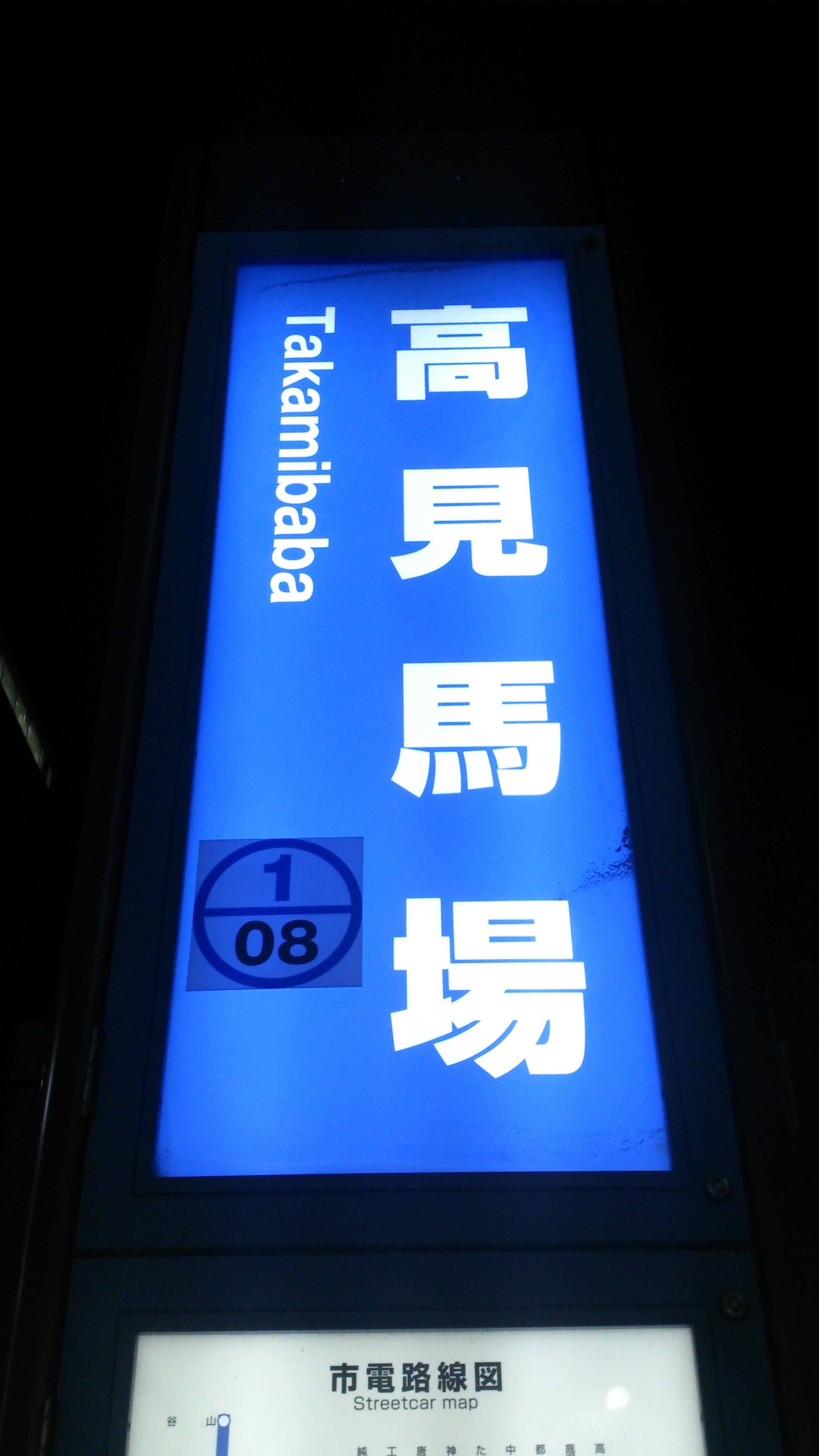 Bright blue sign for Takamibaba station with Japanese characters