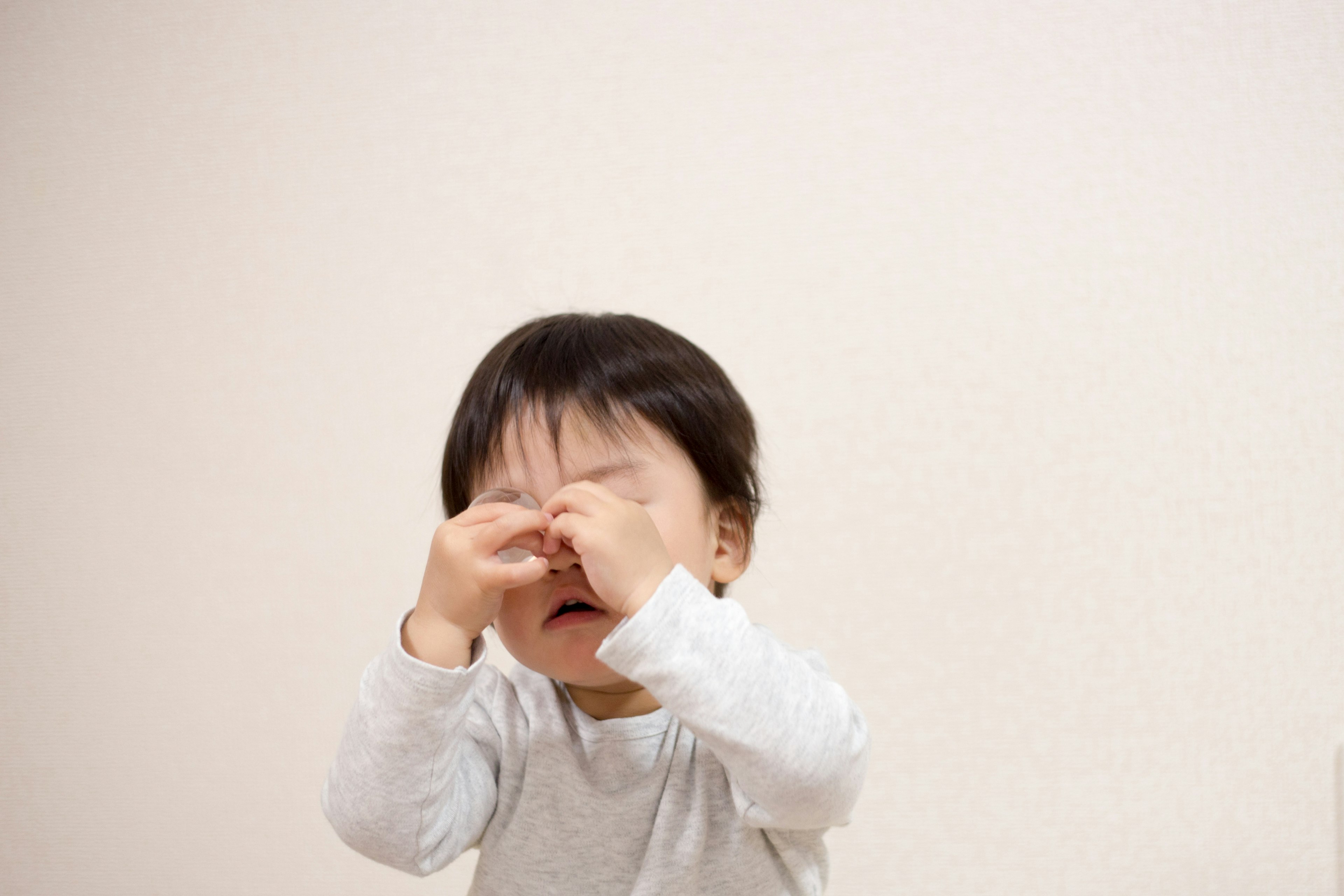 Seorang anak kecil menggosok matanya