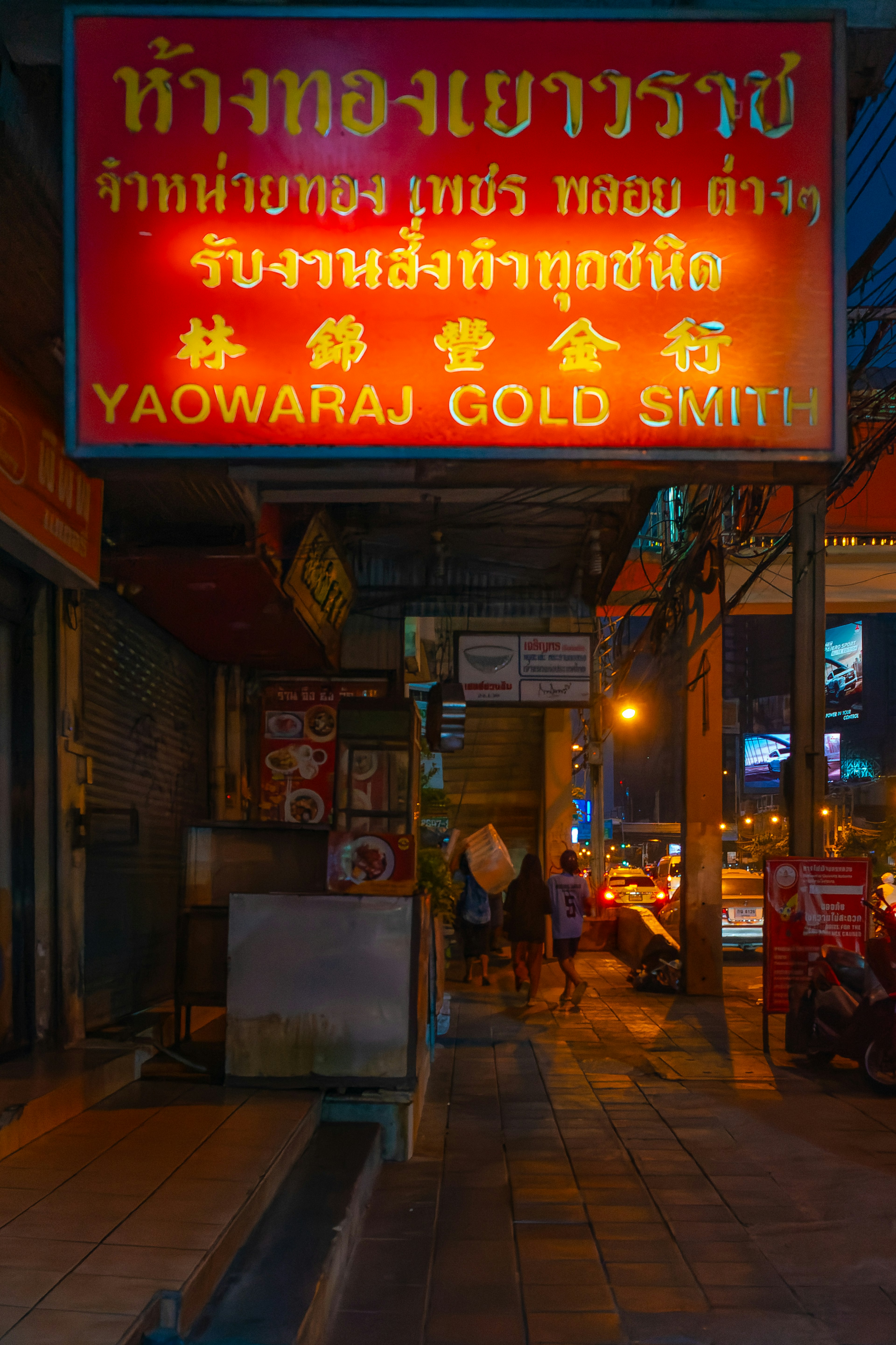 Cartel iluminado de Yaowaraj Gold Smith en una calle poco iluminada