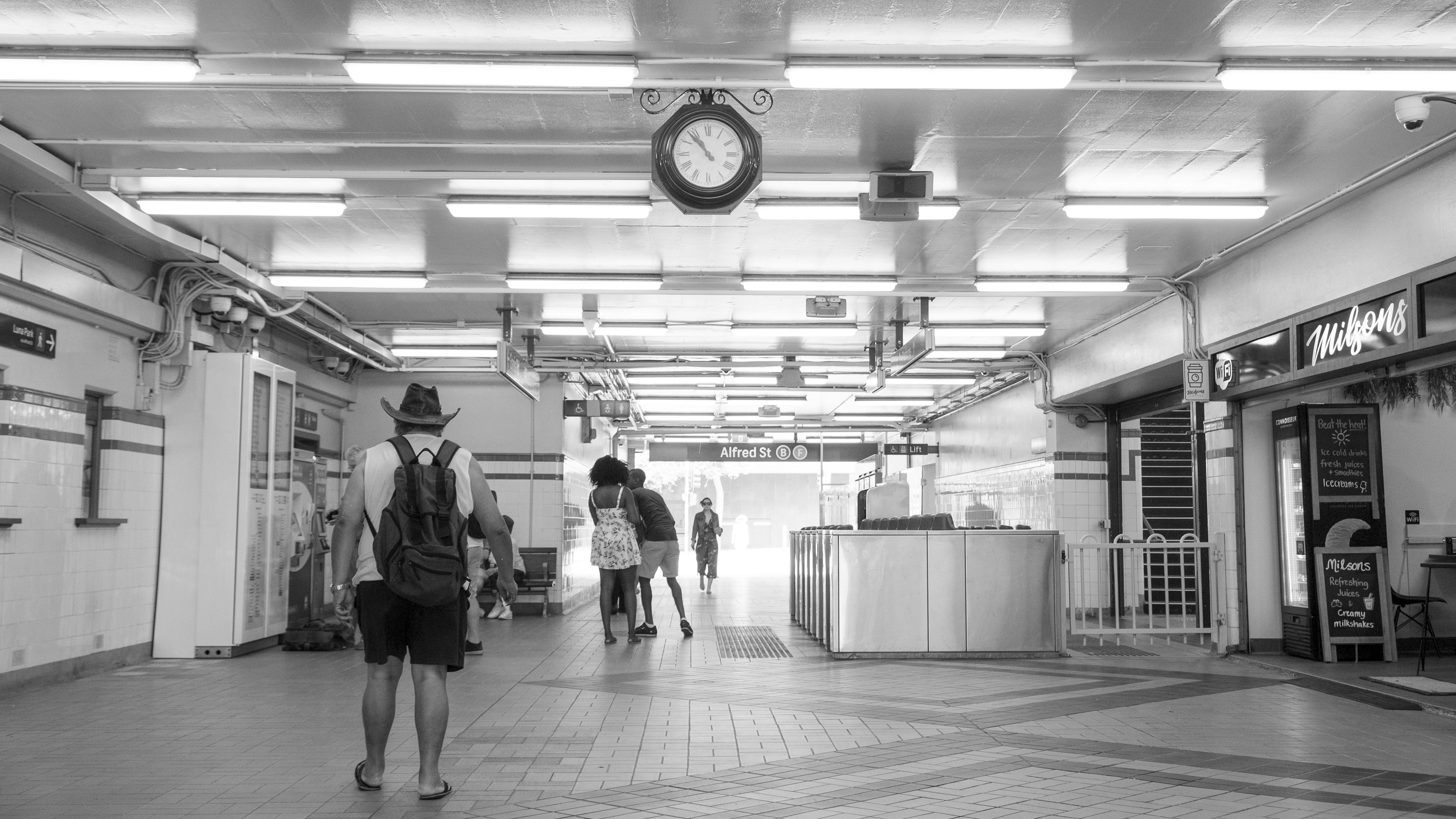 Interior en blanco y negro con personas y un reloj