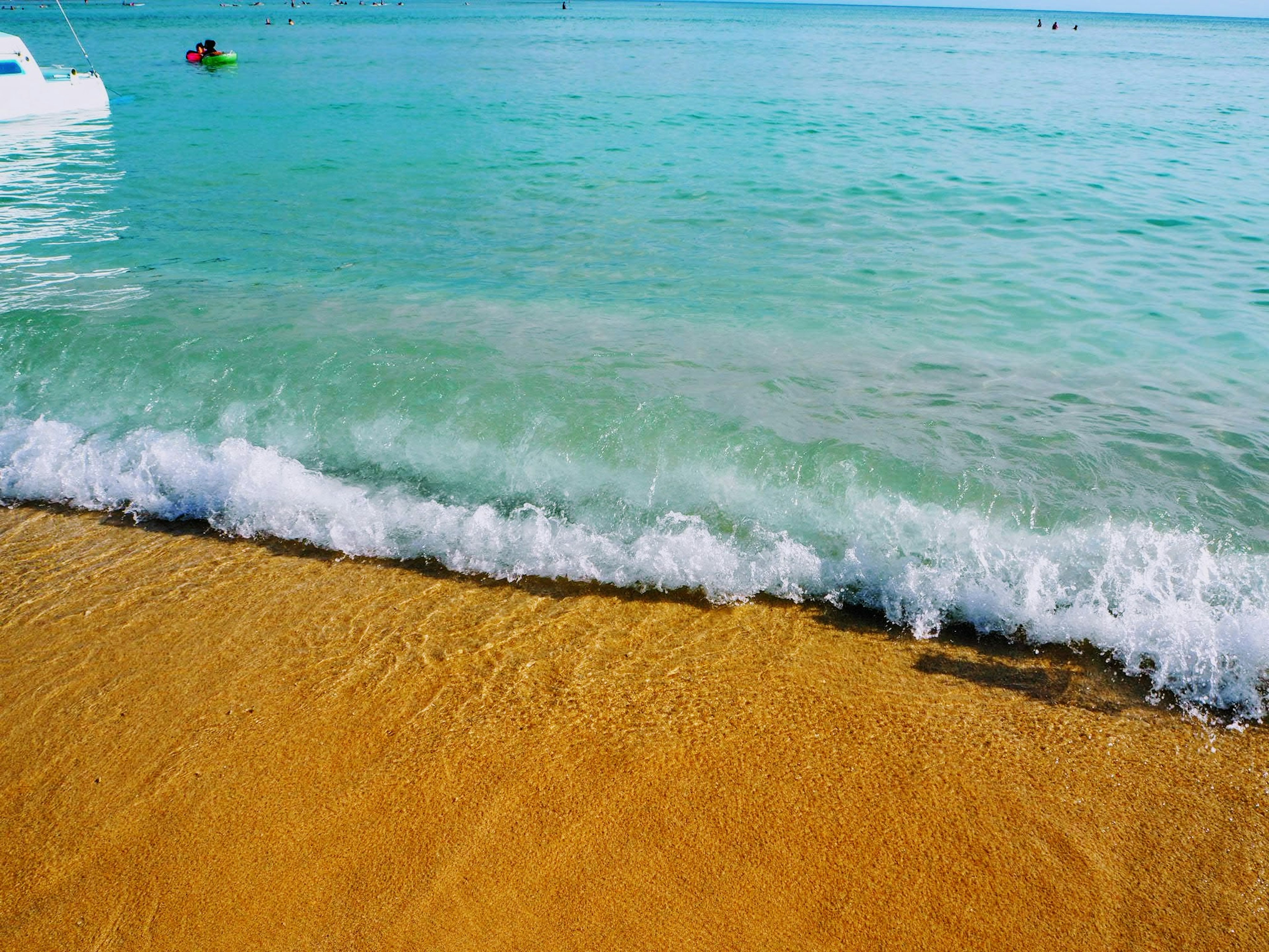 Escena de playa de arena con océano azul olas golpeando la orilla