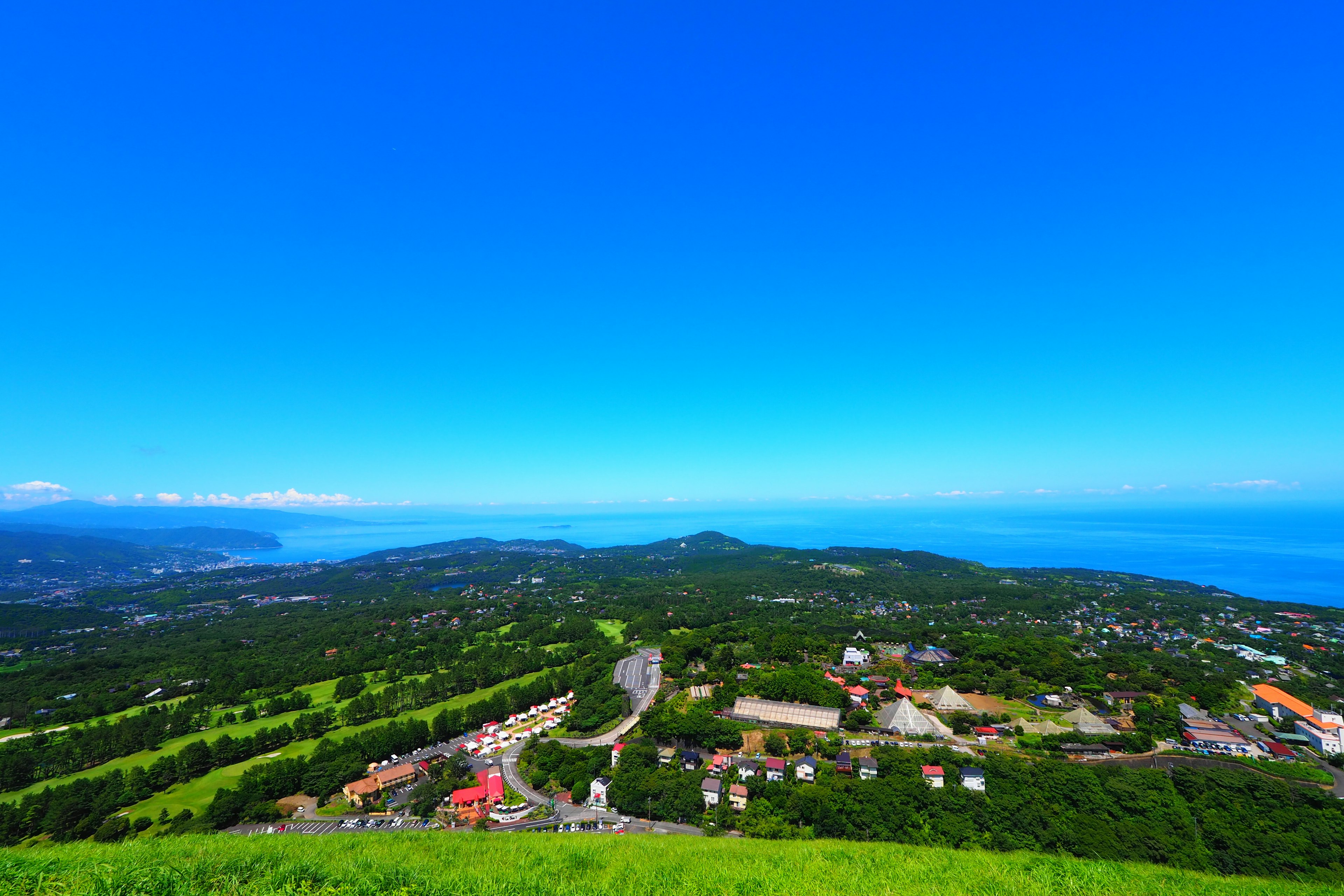 Panoramic view of the sea with blue sky and green landscape