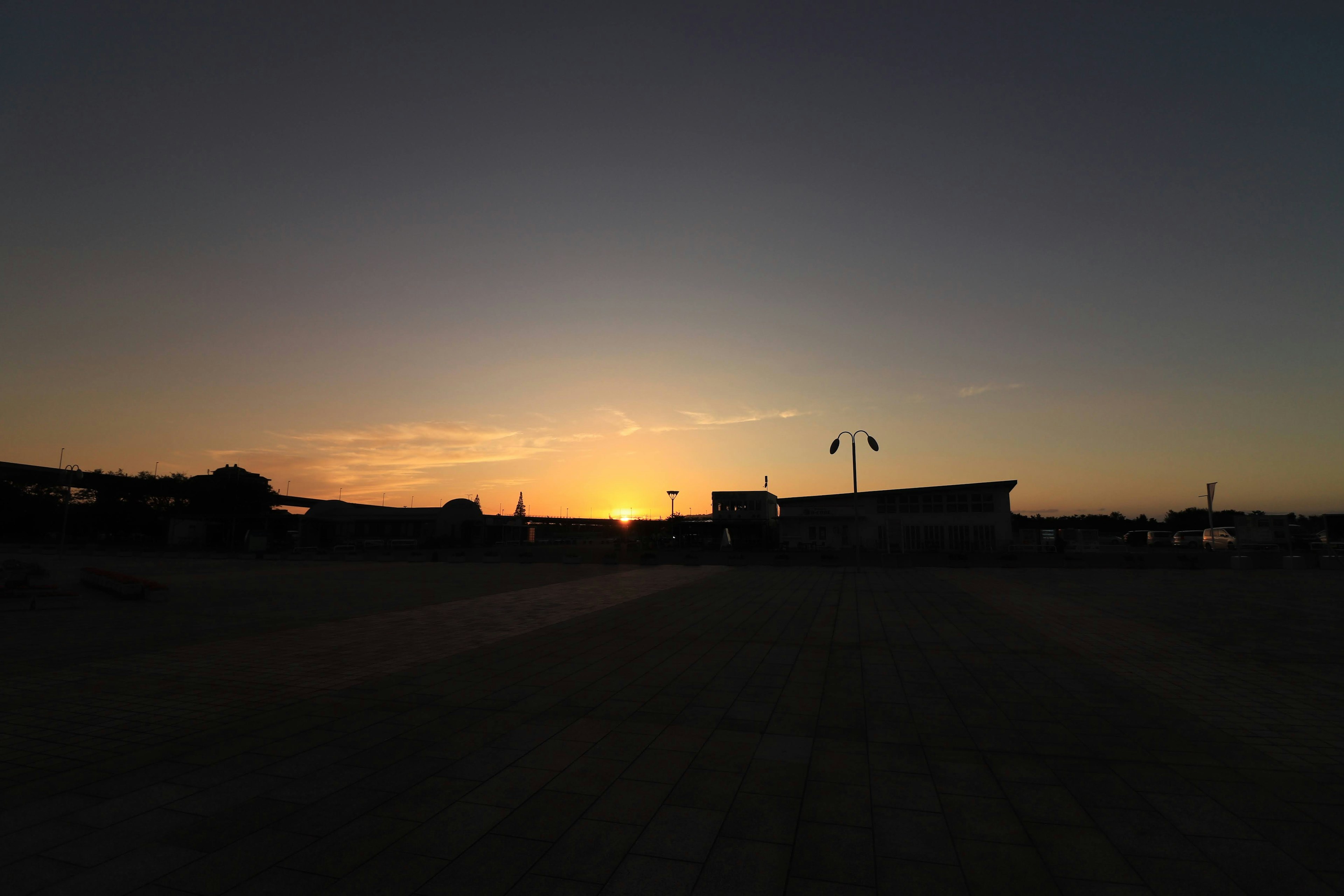 夕焼けの空にシルエットの建物が見える風景