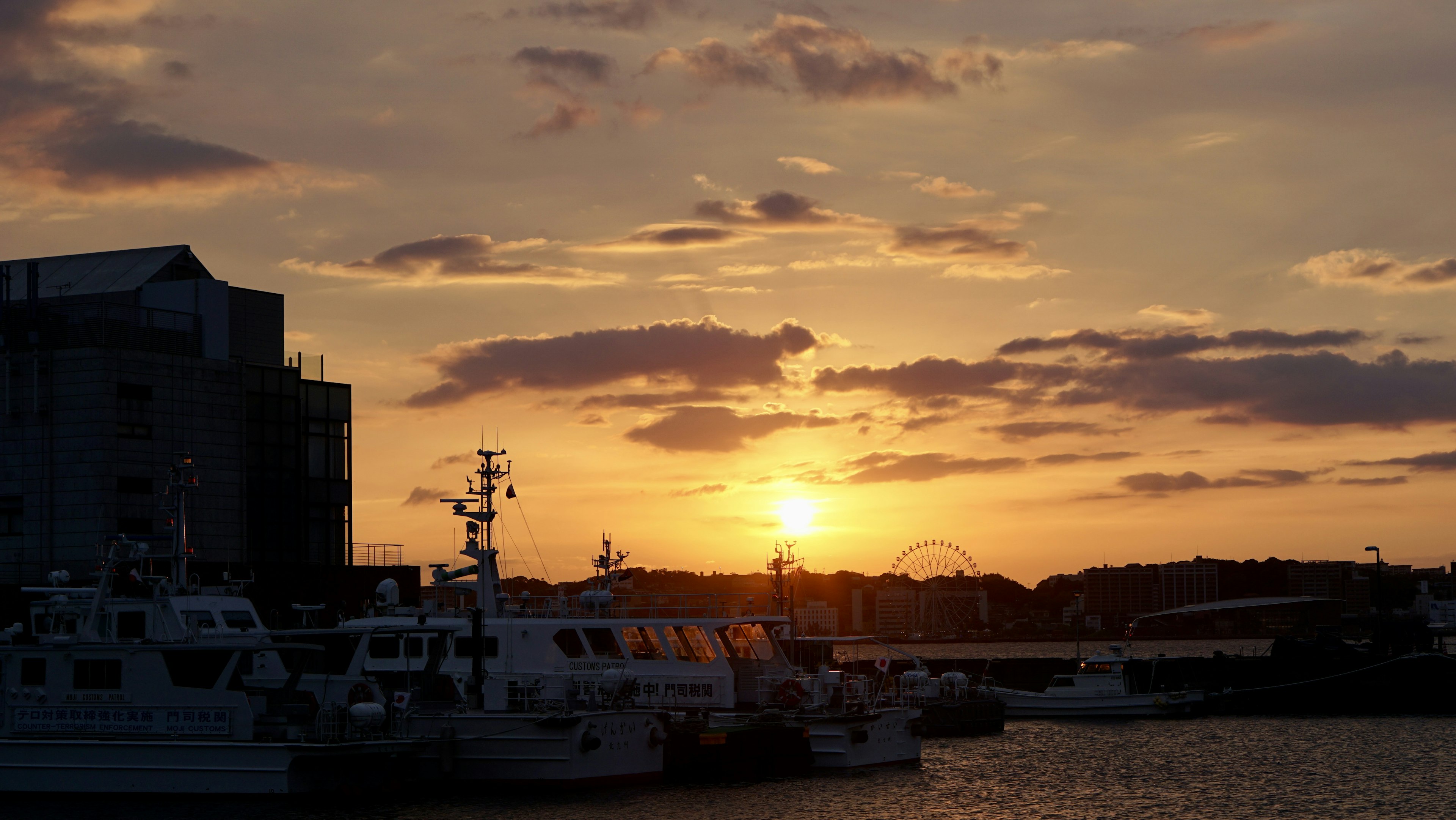 Escena de puerto al atardecer con barcos alineados