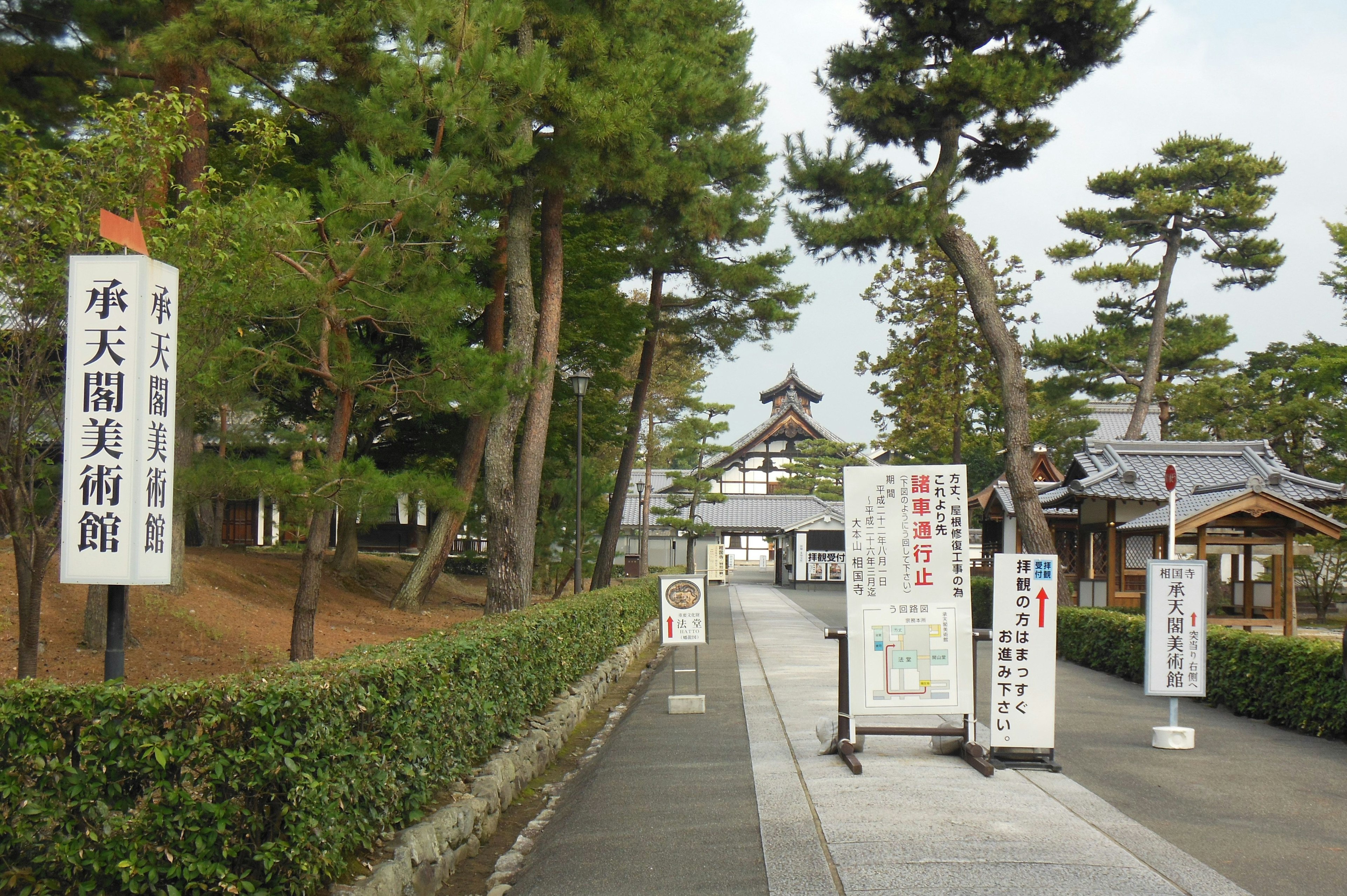 Entrance view of a museum surrounded by pine trees