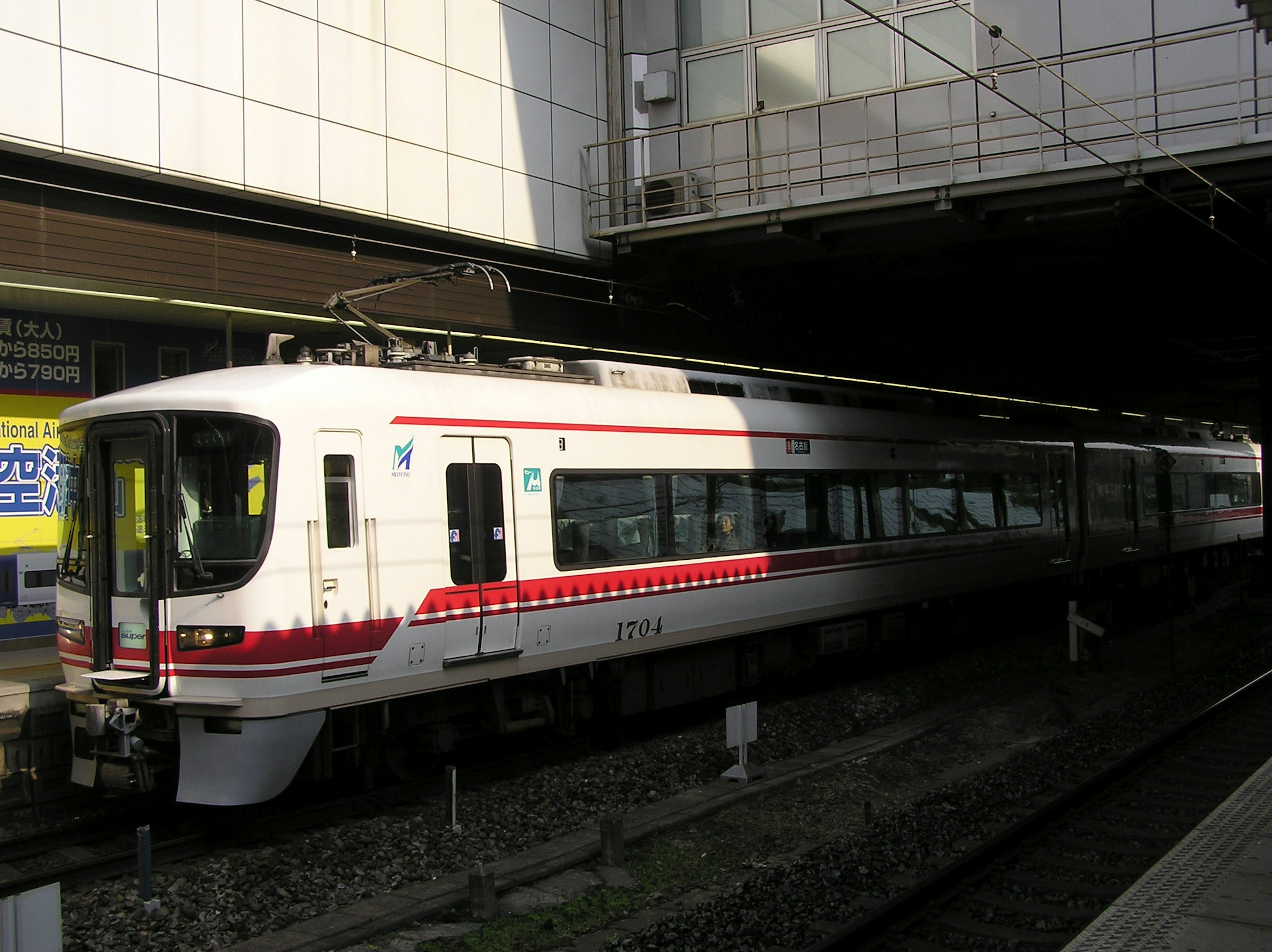 Weißer Zug mit roten Streifen am Bahnhof geparkt