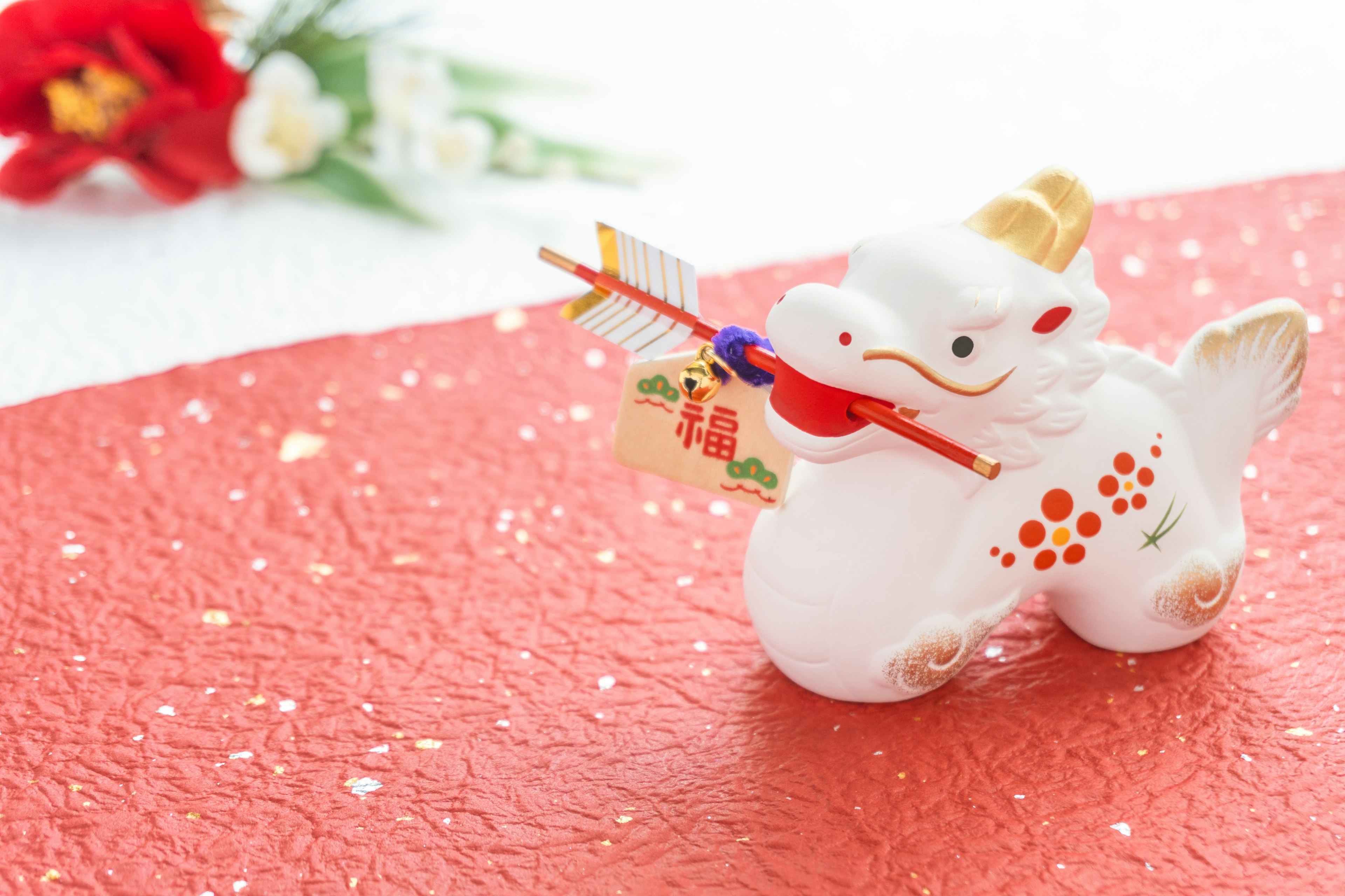 A white lion figurine holding a musical instrument on a red background