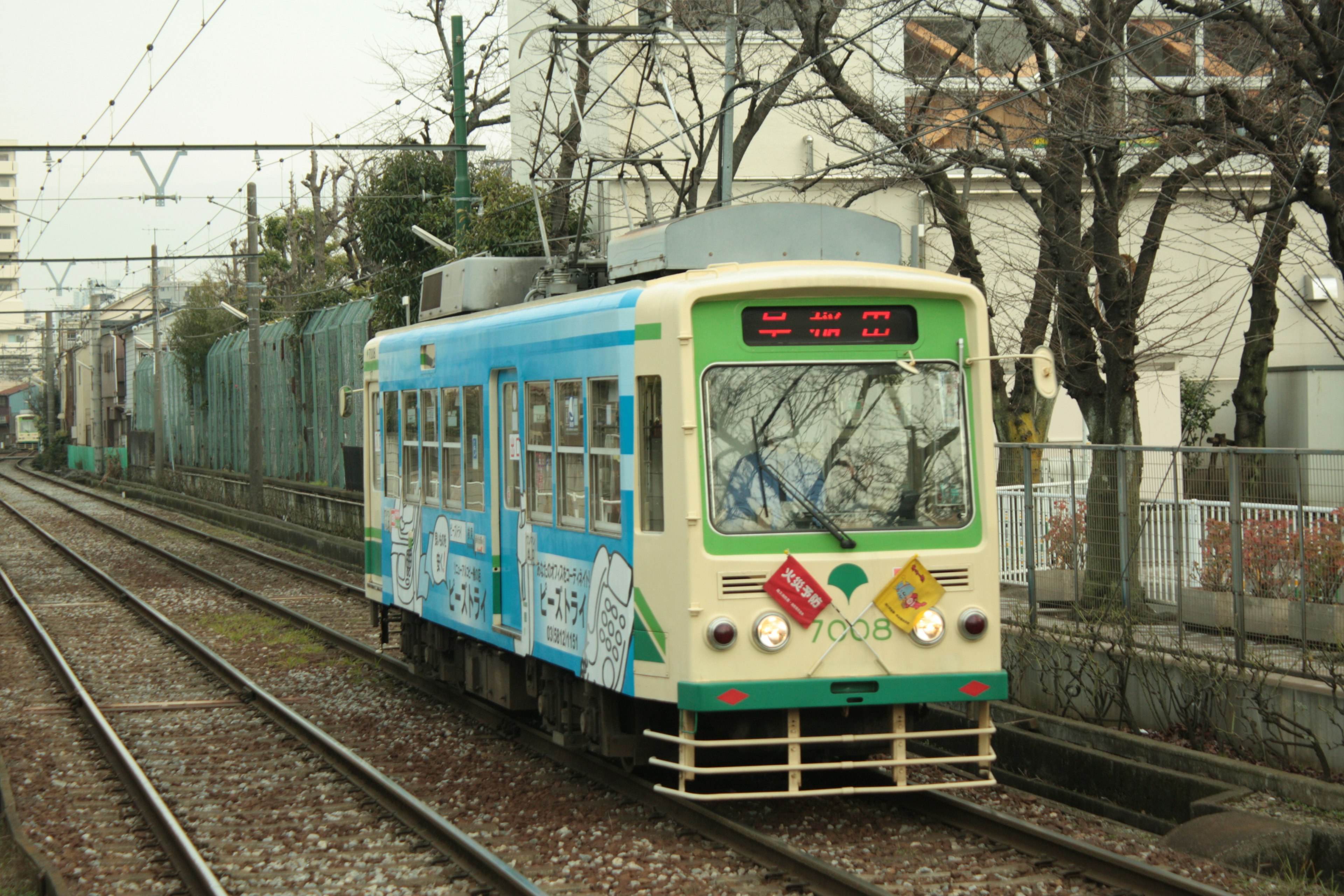 Un tram blu che corre su binari