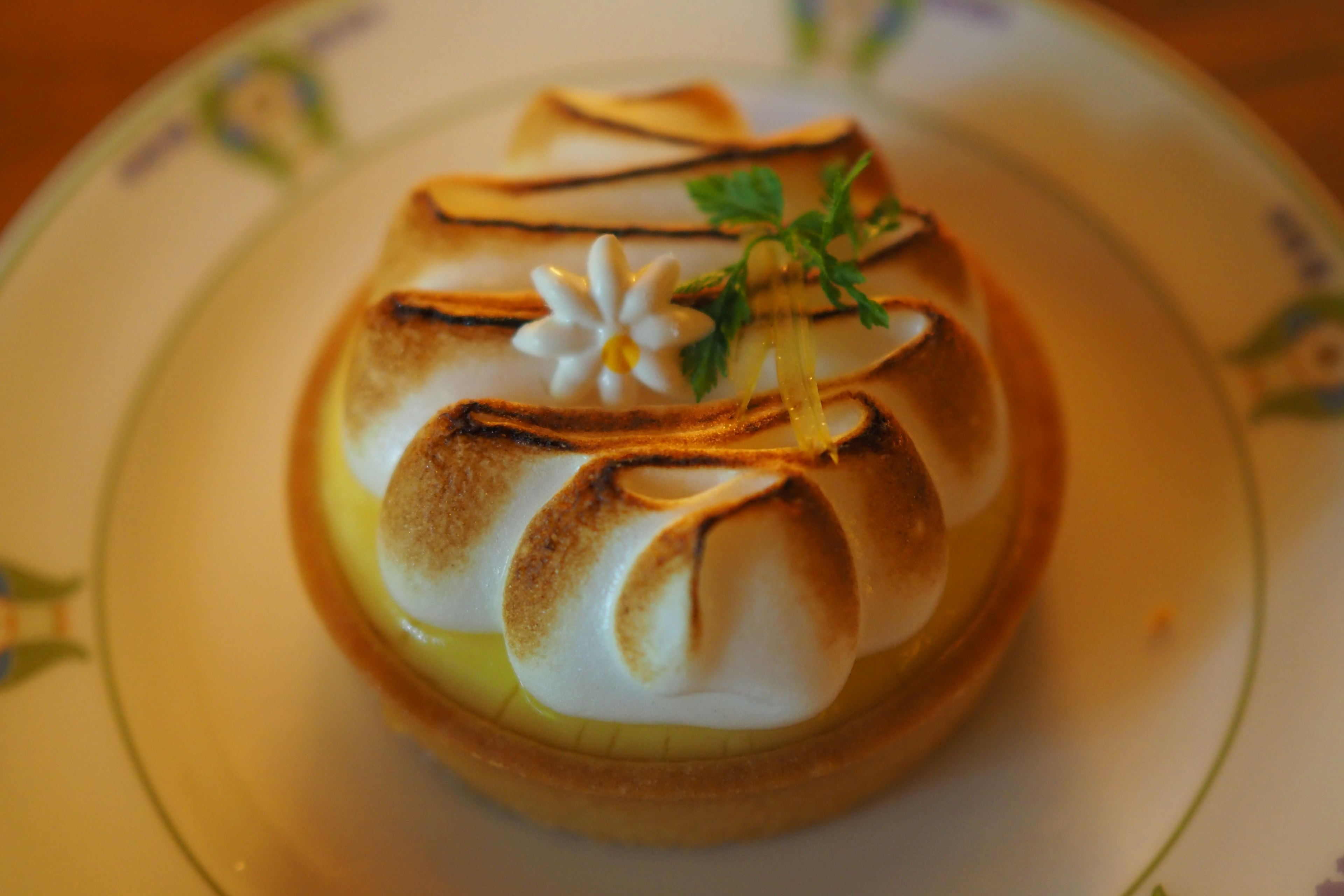 Beautiful lemon tart with meringue topping and floral decoration