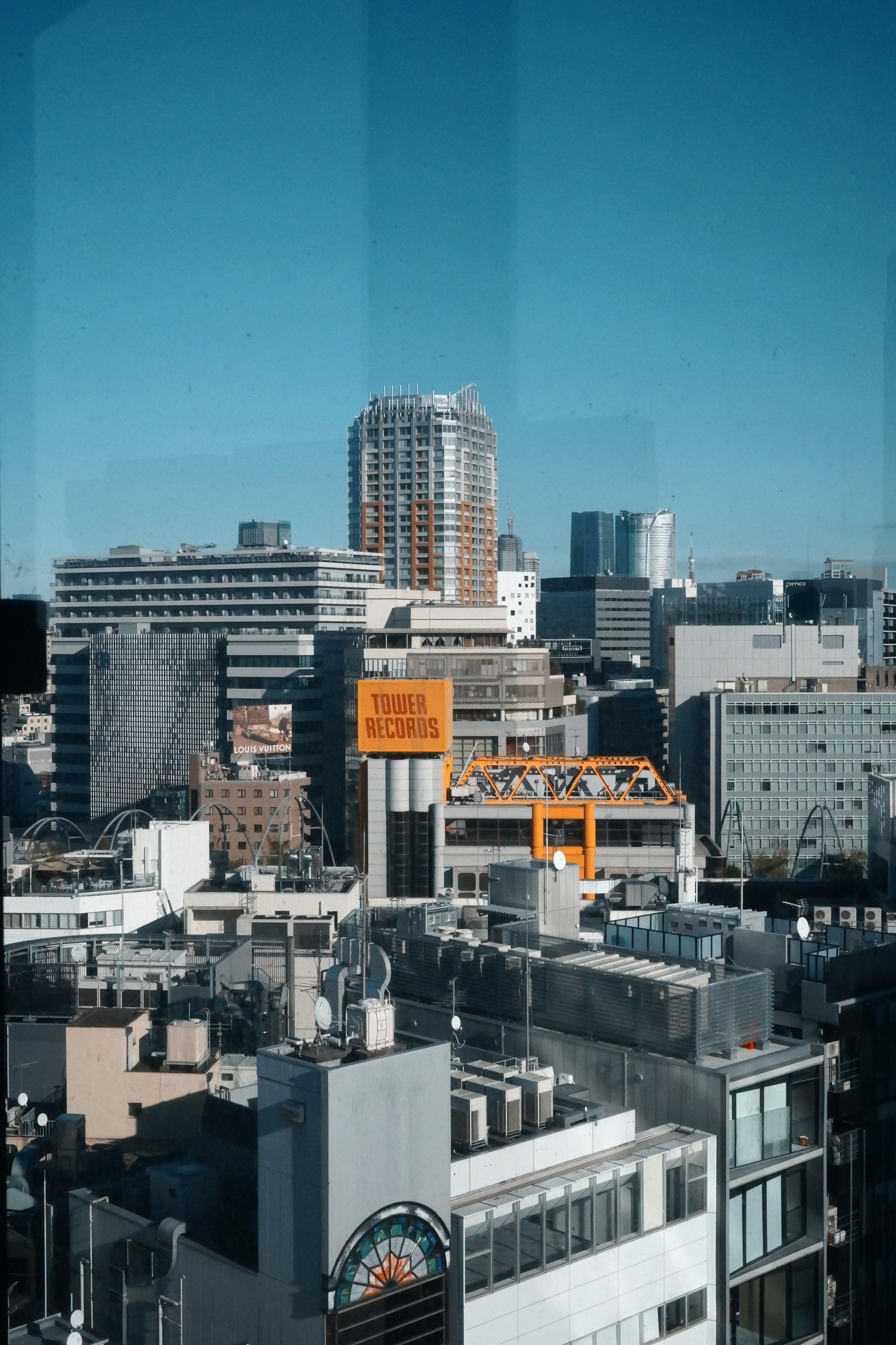 Vista de la ciudad bajo un cielo azul con edificios altos y estructuras comerciales