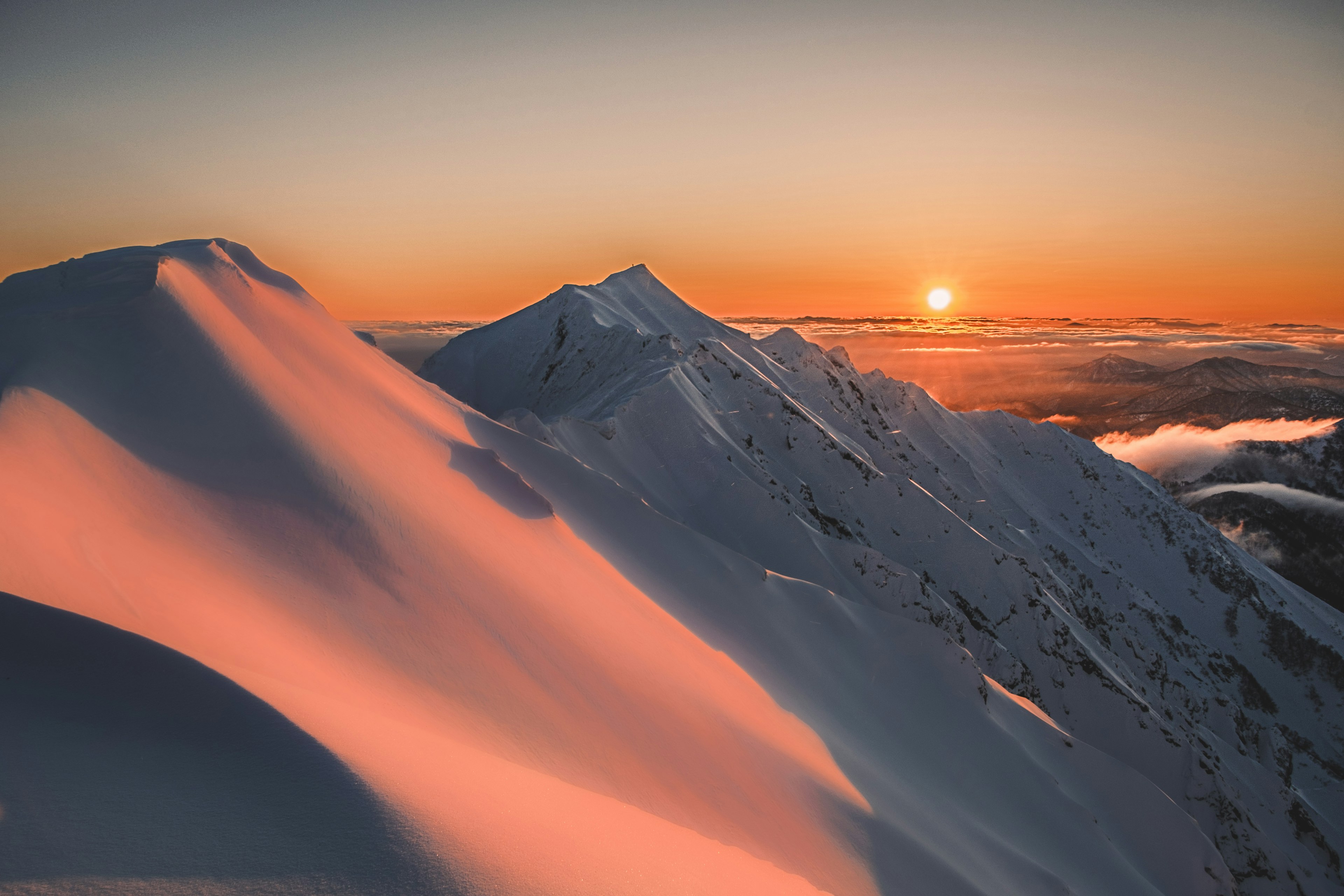 Bellissimo paesaggio montano innevato con luce del tramonto