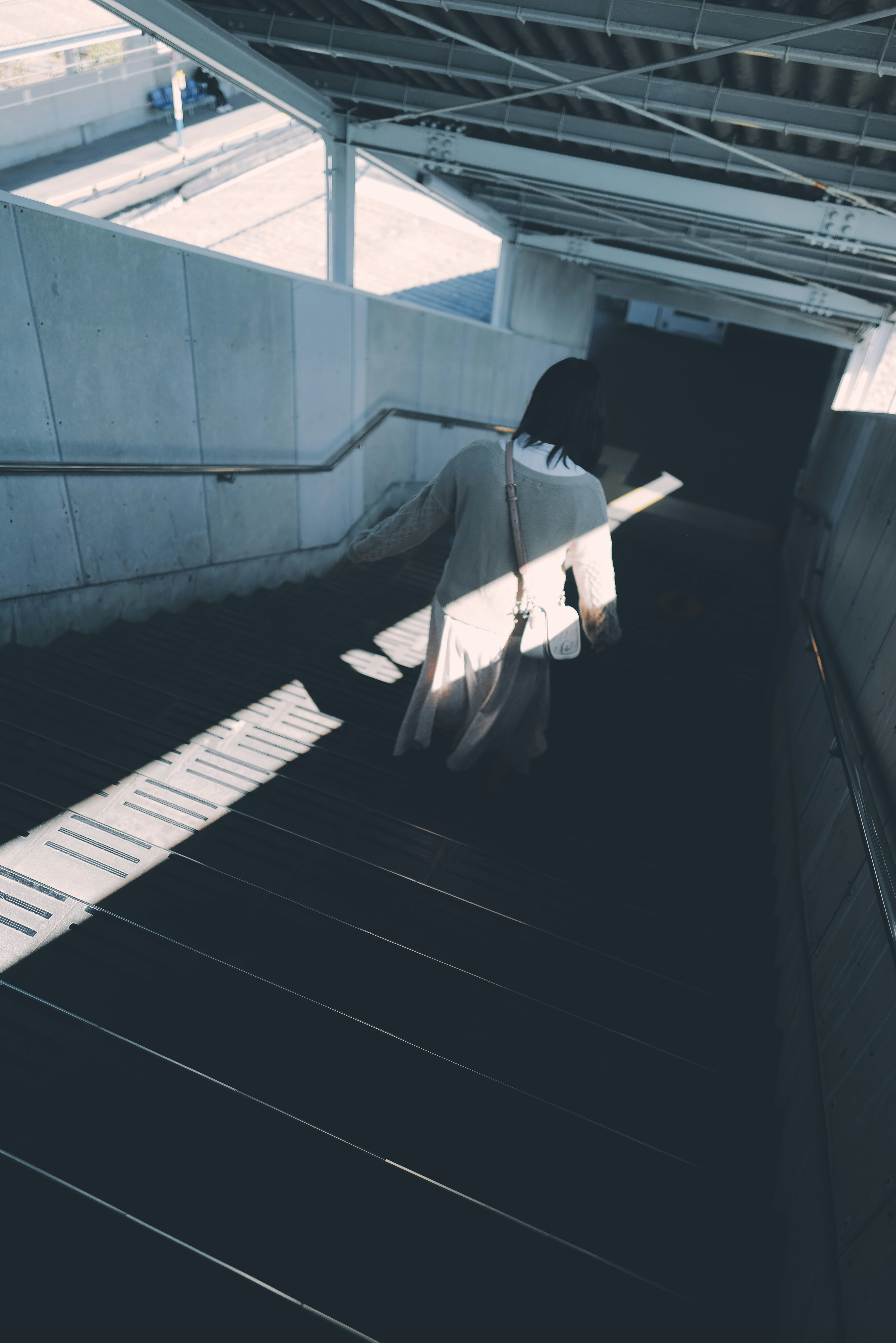 A silhouette descending stairs with striking light contrast