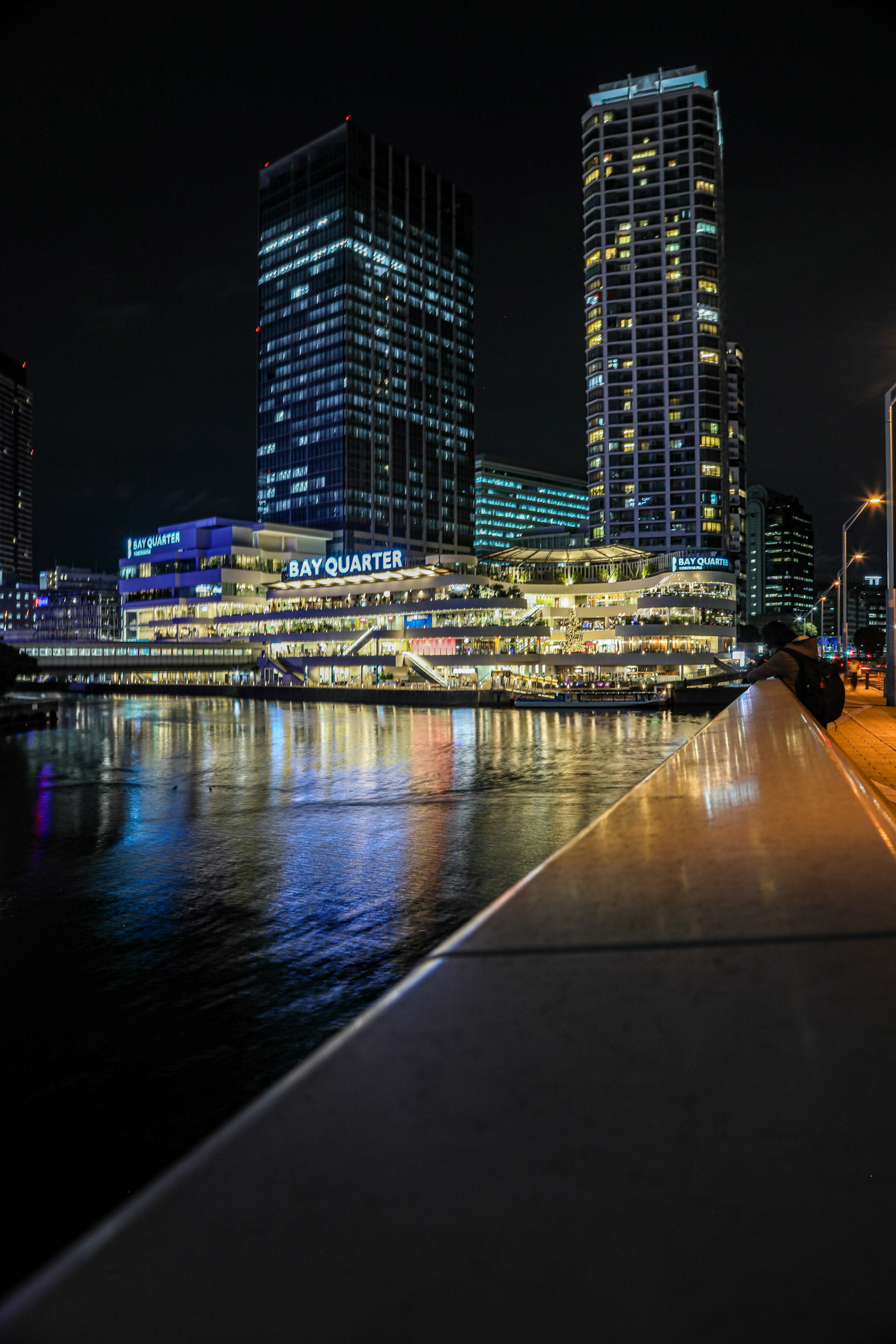 Skyline notturno della città con edifici illuminati che si riflettono nell'acqua