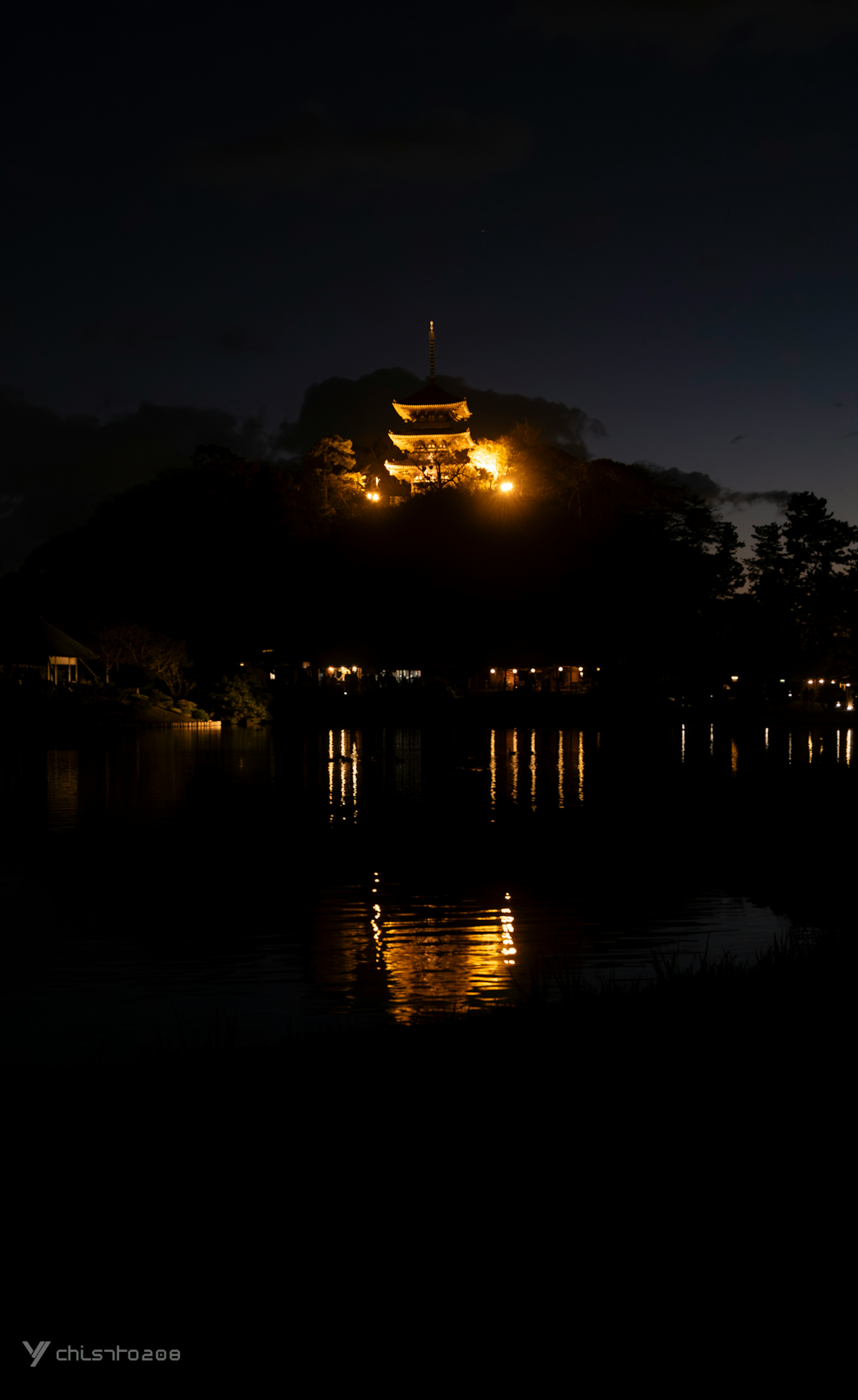 夜の湖の上に浮かぶ明かりが灯る城