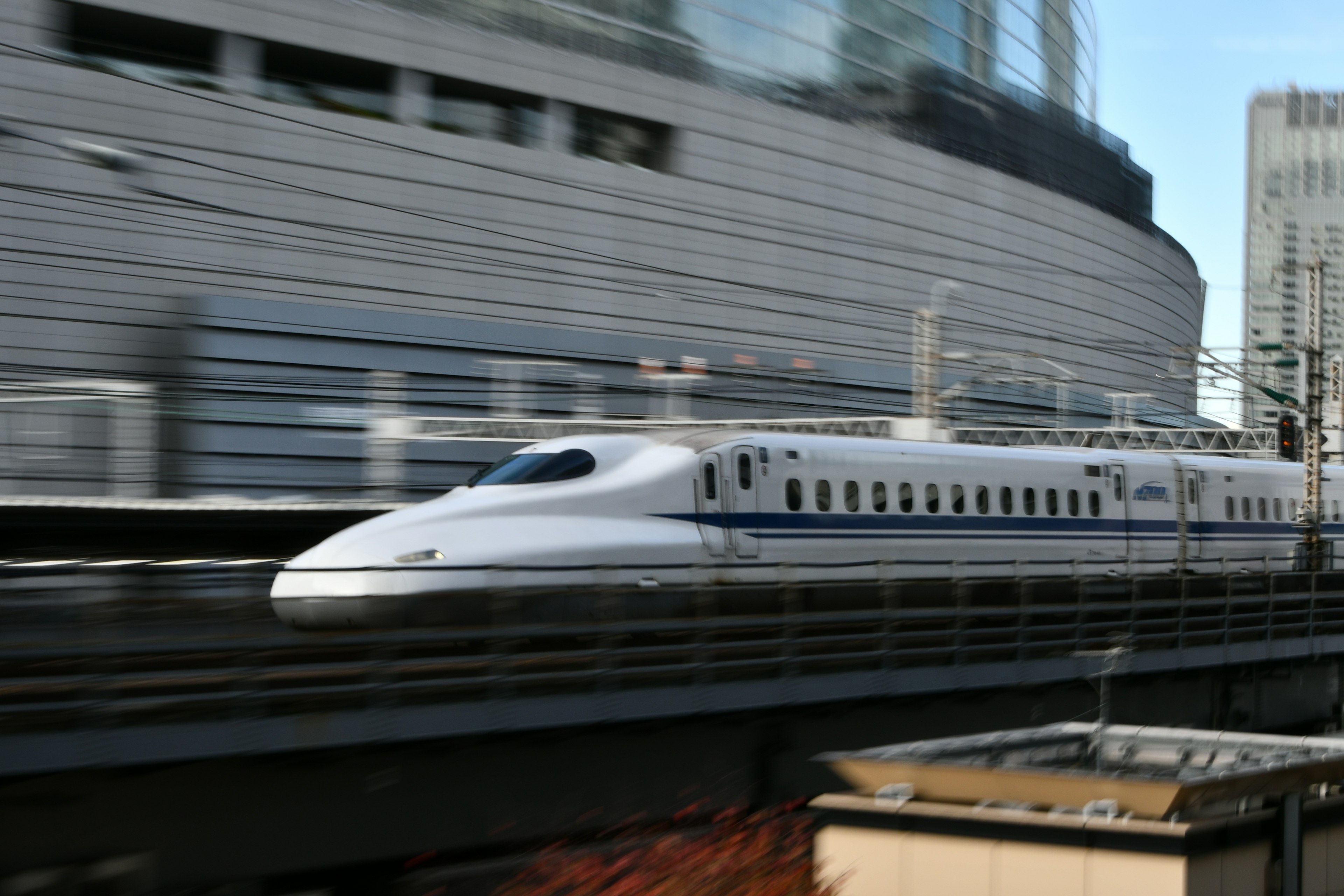 Shinkansen melaju melalui pemandangan perkotaan