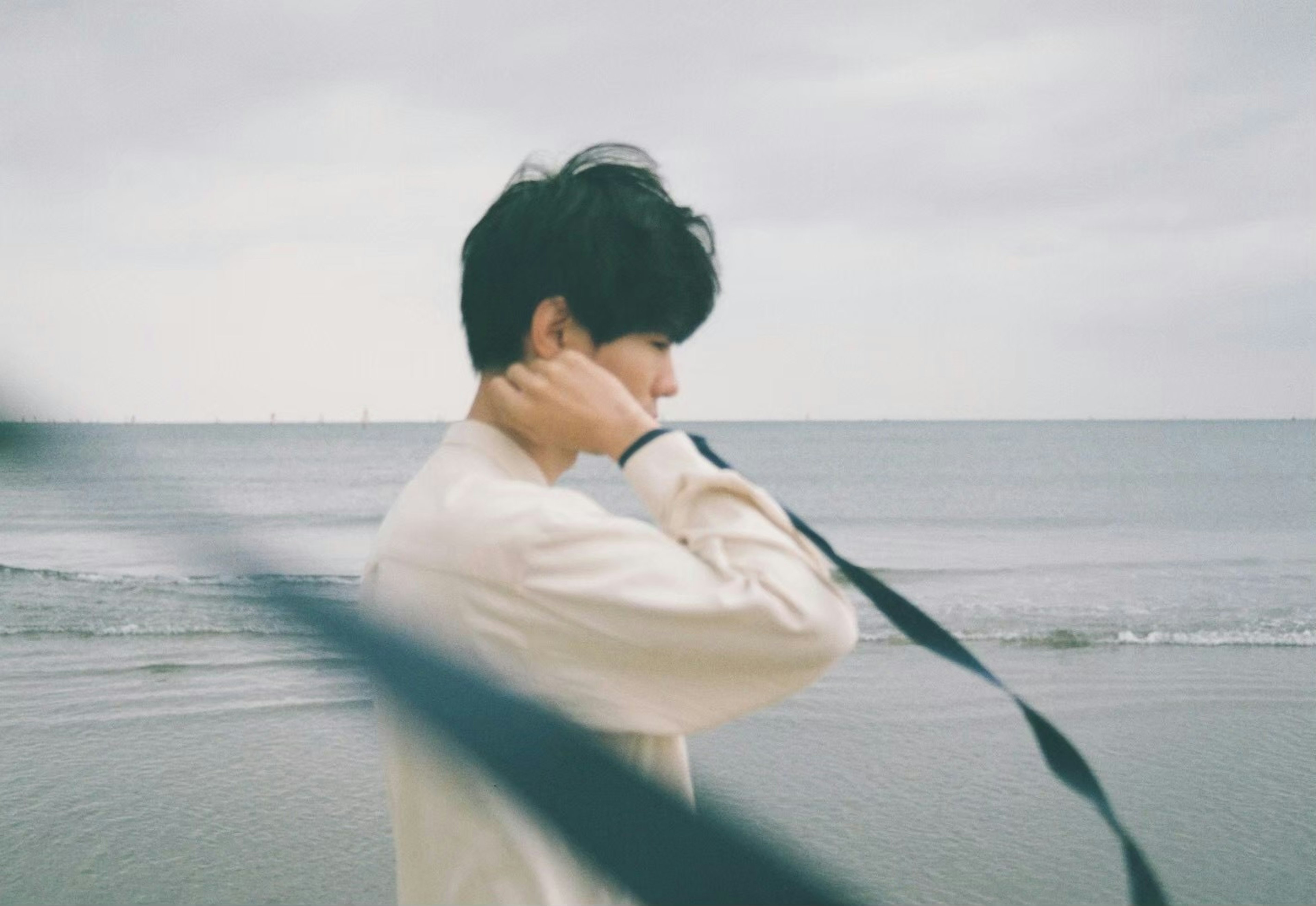 Side profile of a man brushing his hair at the beach