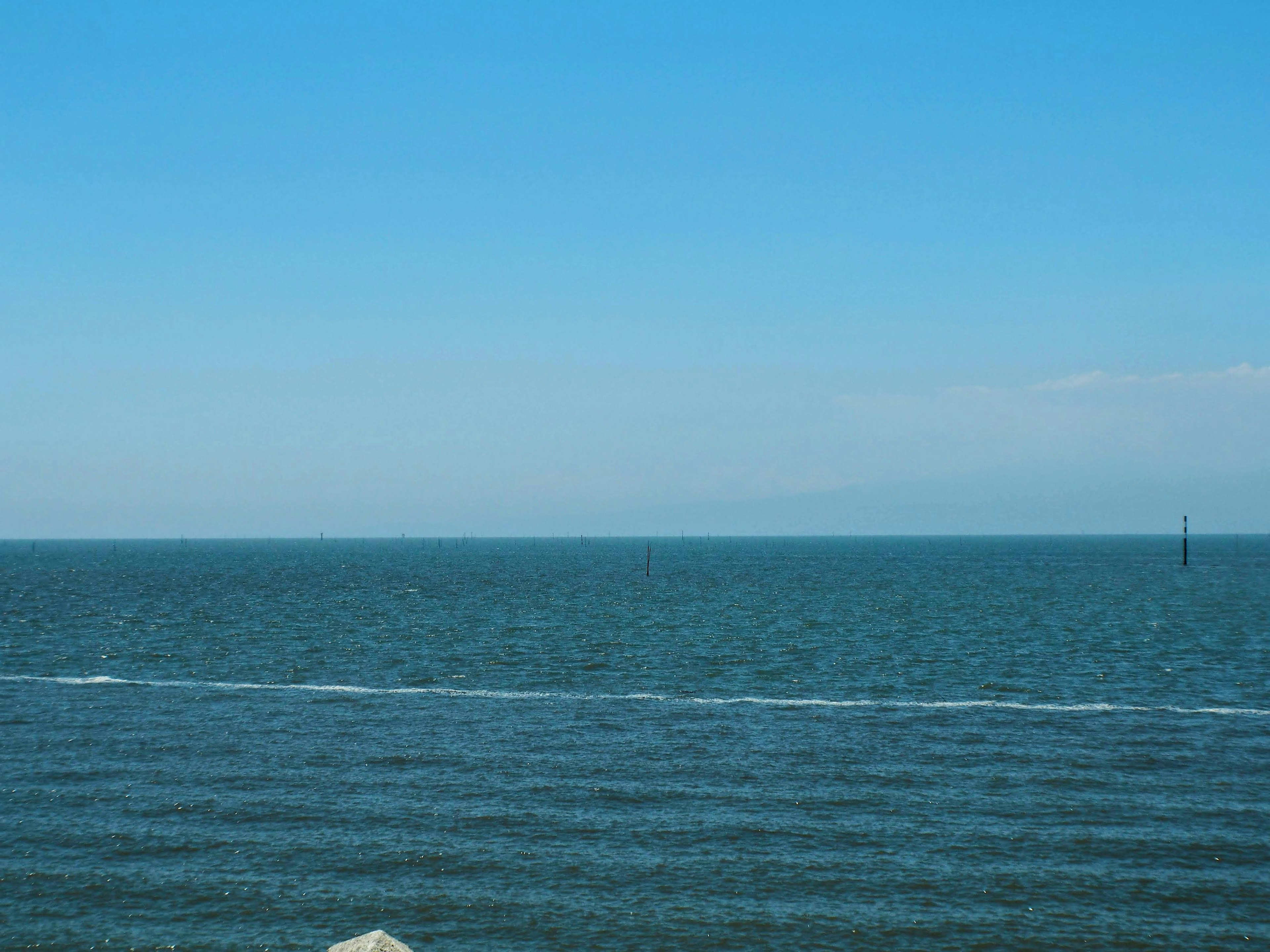 Pemandangan laut dan langit biru dengan riak terlihat di air