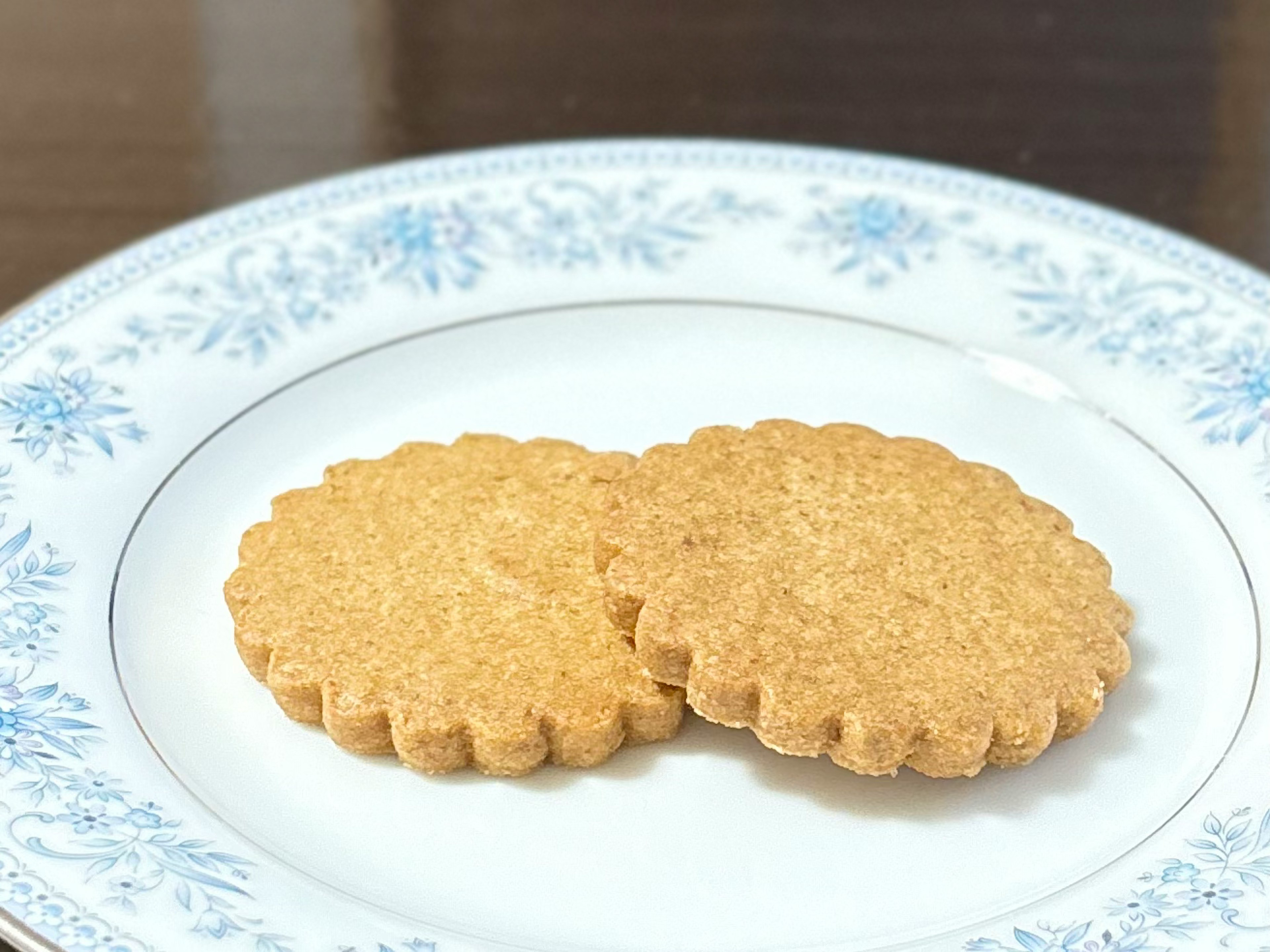 Deux biscuits sur une assiette à motif floral bleu