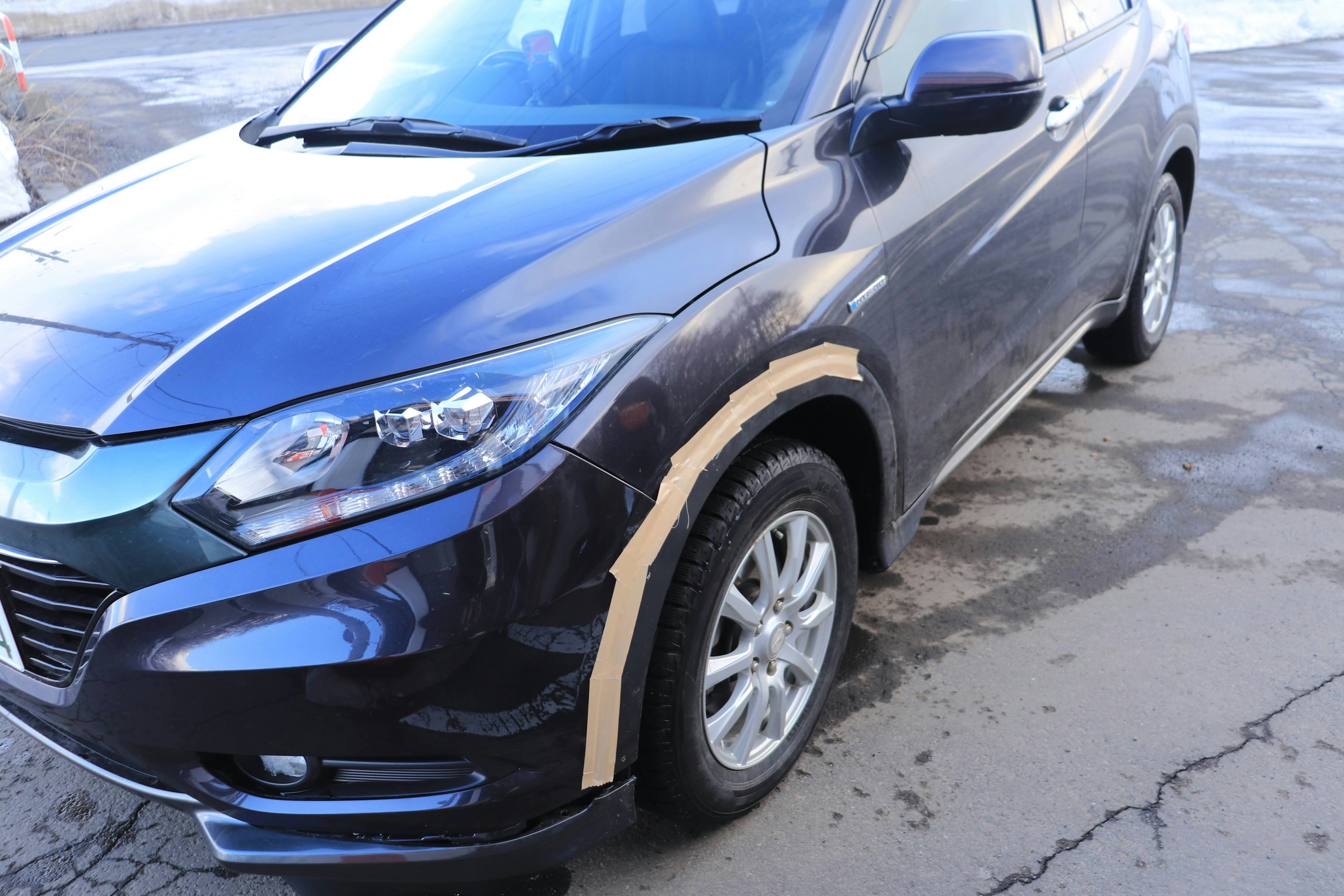 Voiture SUV noire avec du ruban protecteur sur l'aile avant